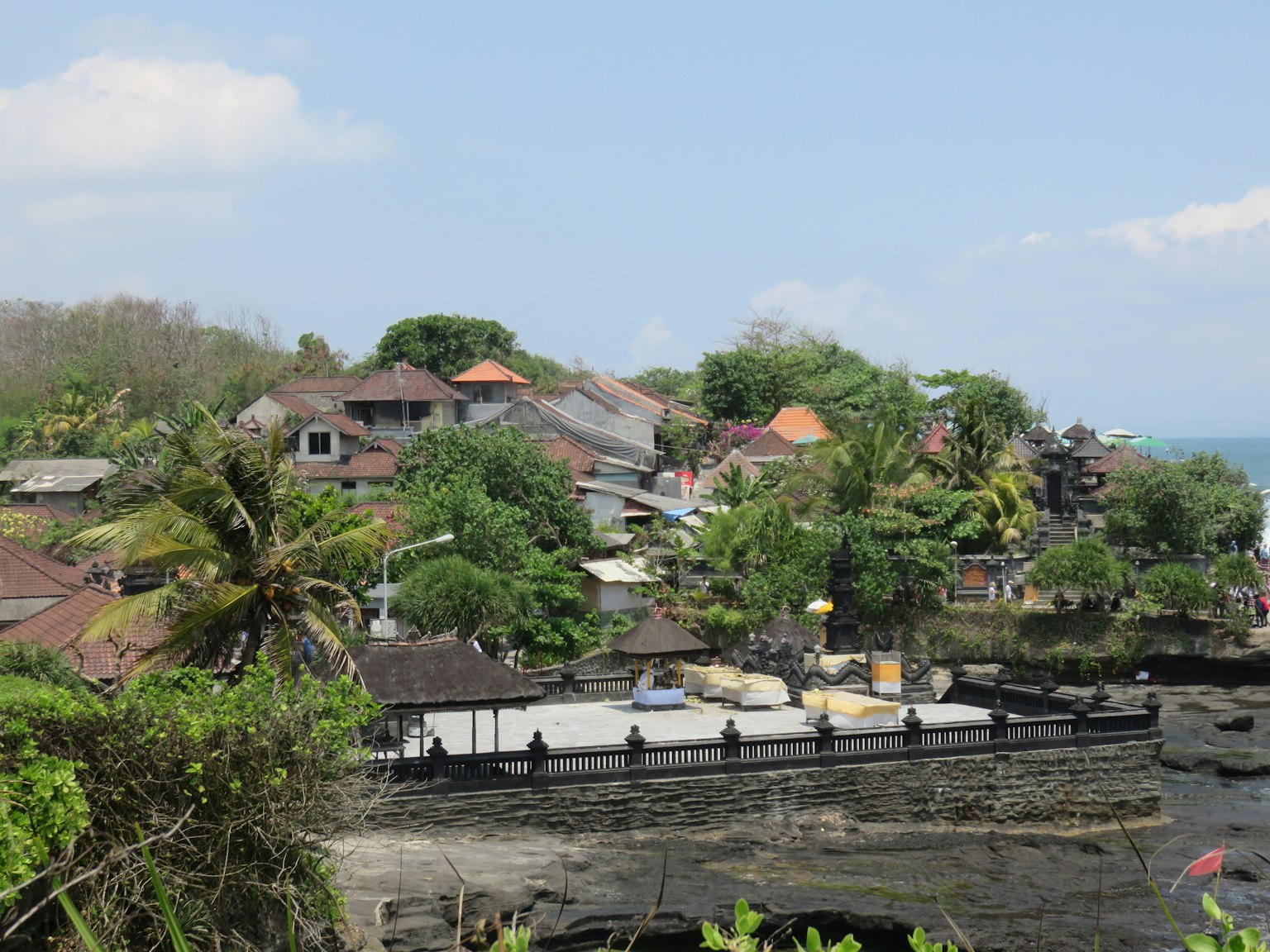 Vue pittoresque d'un village balinais avec verdure luxuriante et bateaux traditionnels