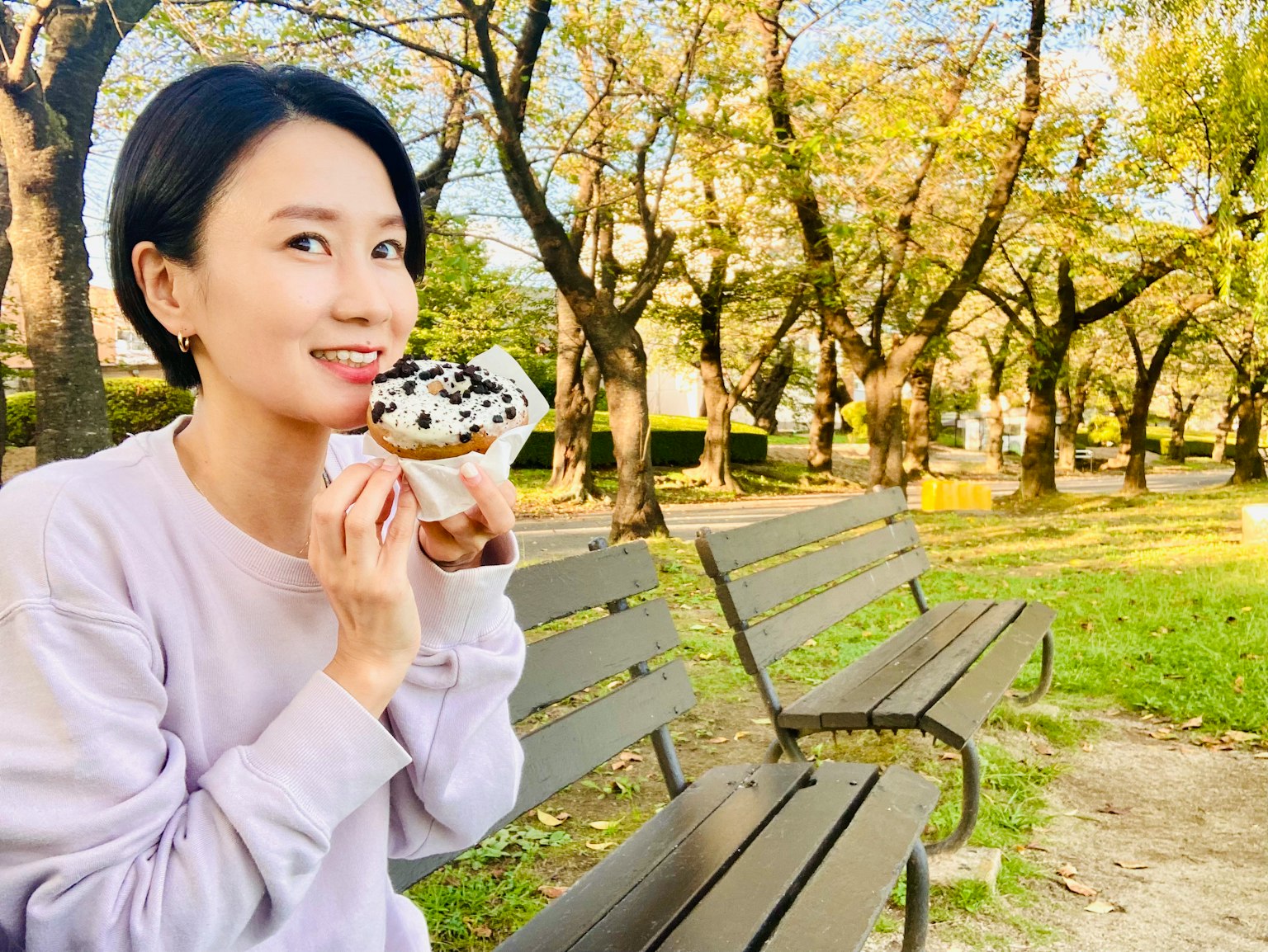 公园中享受甜点的女性与秋季风景