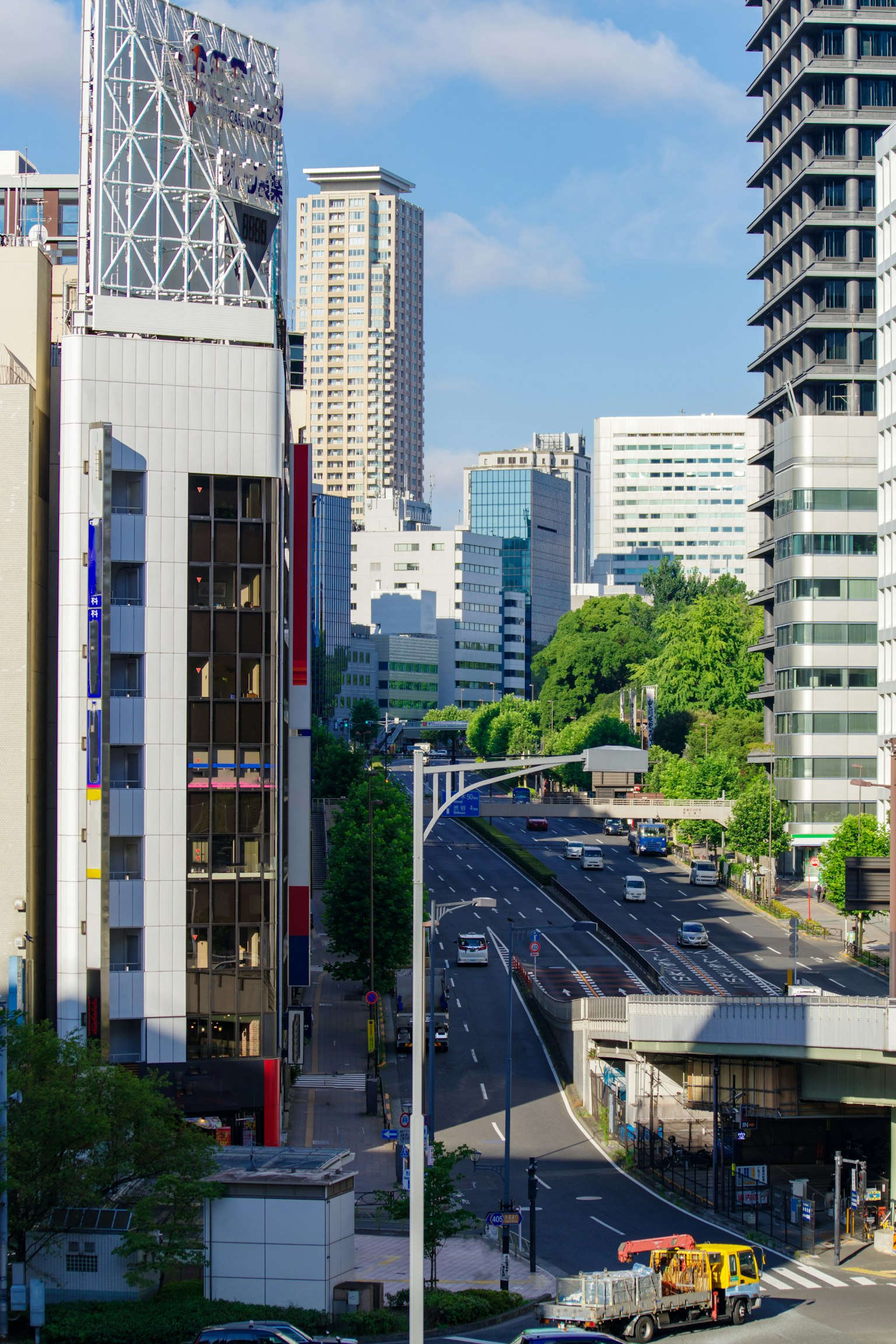 Städtische Skyline mit Hochhäusern und einer Straße unter blauem Himmel