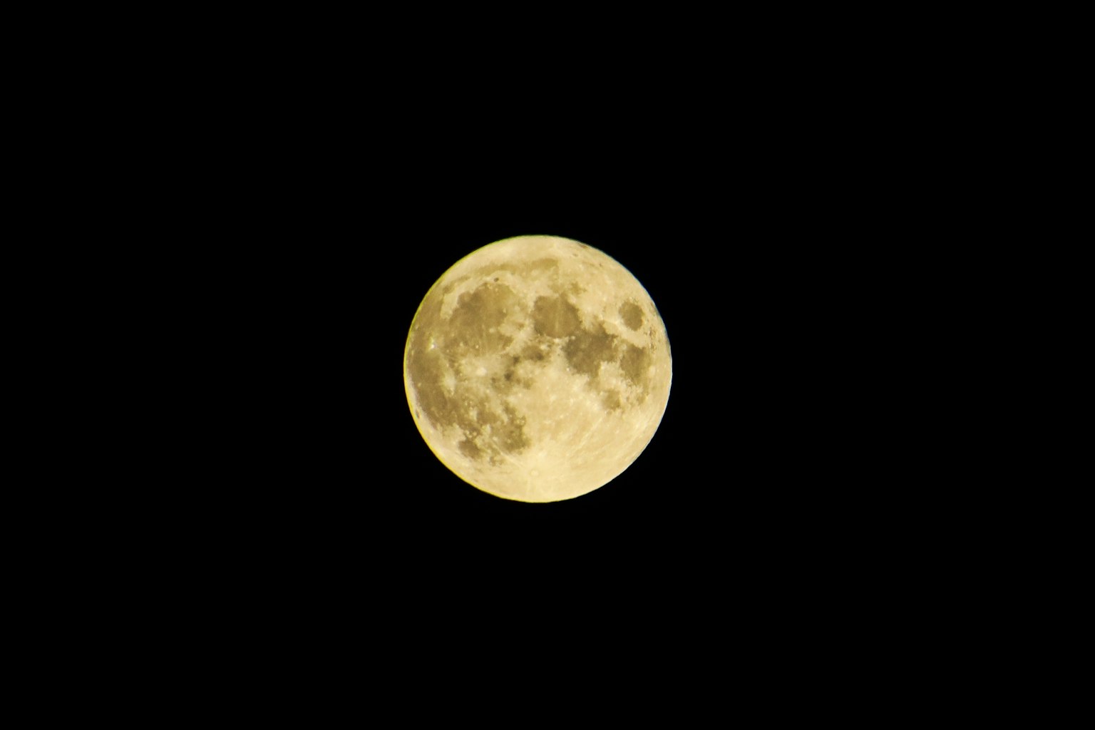 Bright yellow full moon against a black background