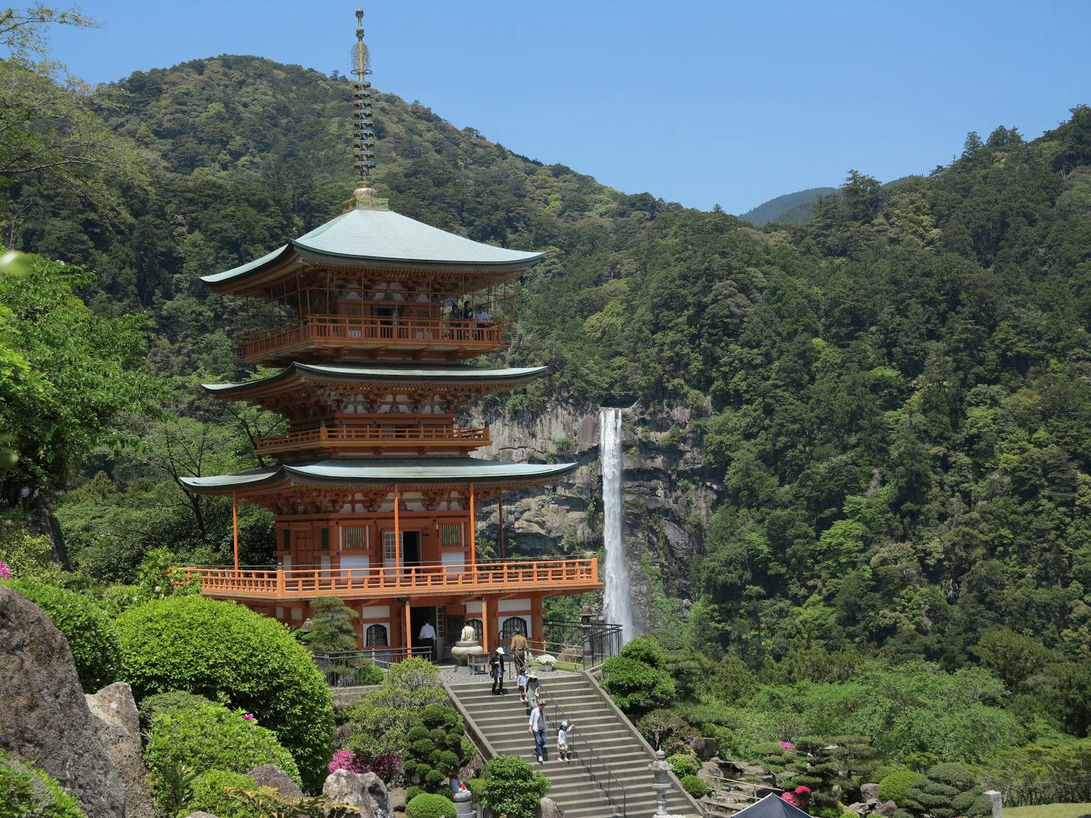 被郁郁葱葱的绿树和瀑布环绕的传统日本寺庙