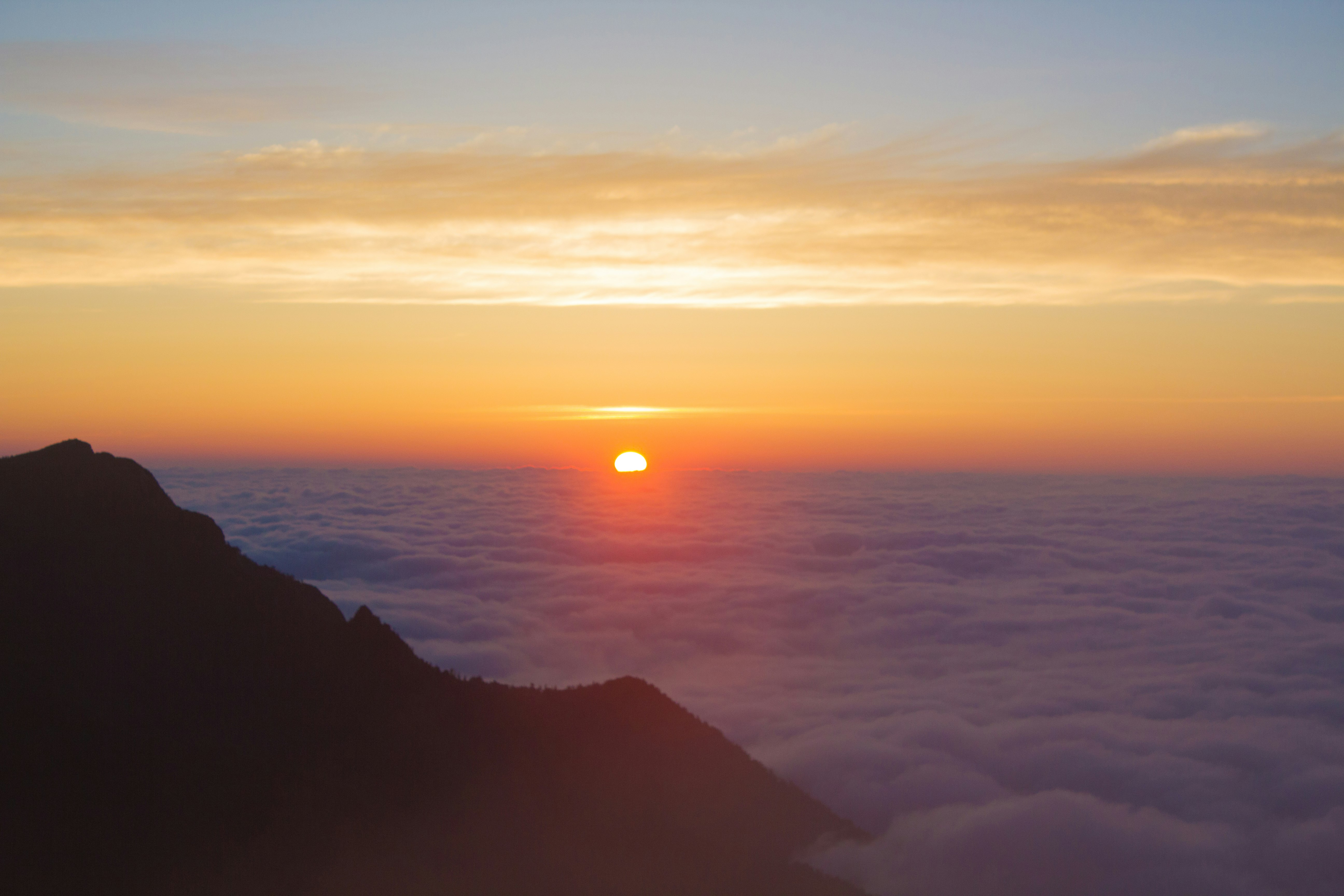 常念岳の雲海から望む日の出の山岳風景