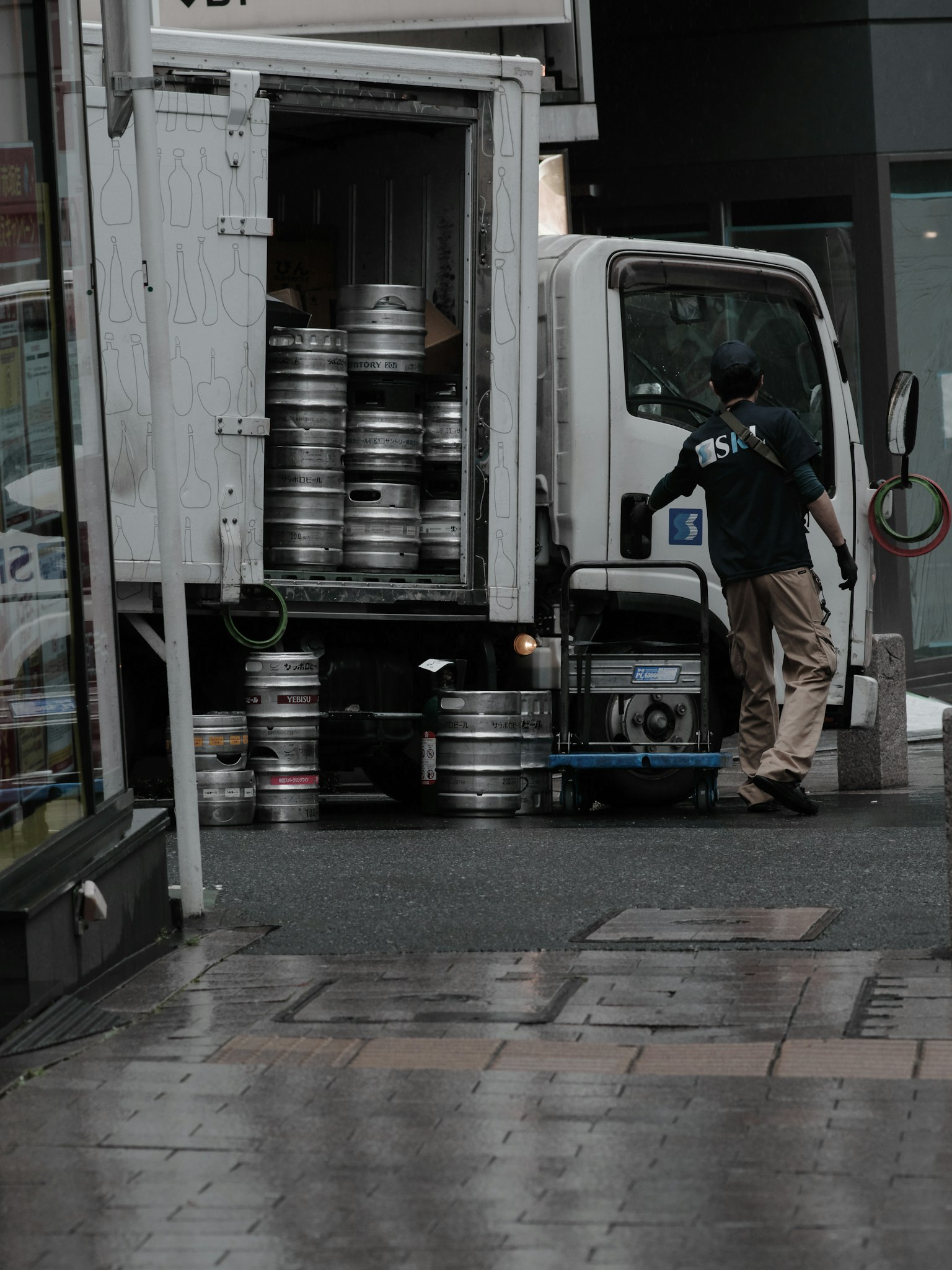 Arbeiter lädt Bierfässer in einen Lkw