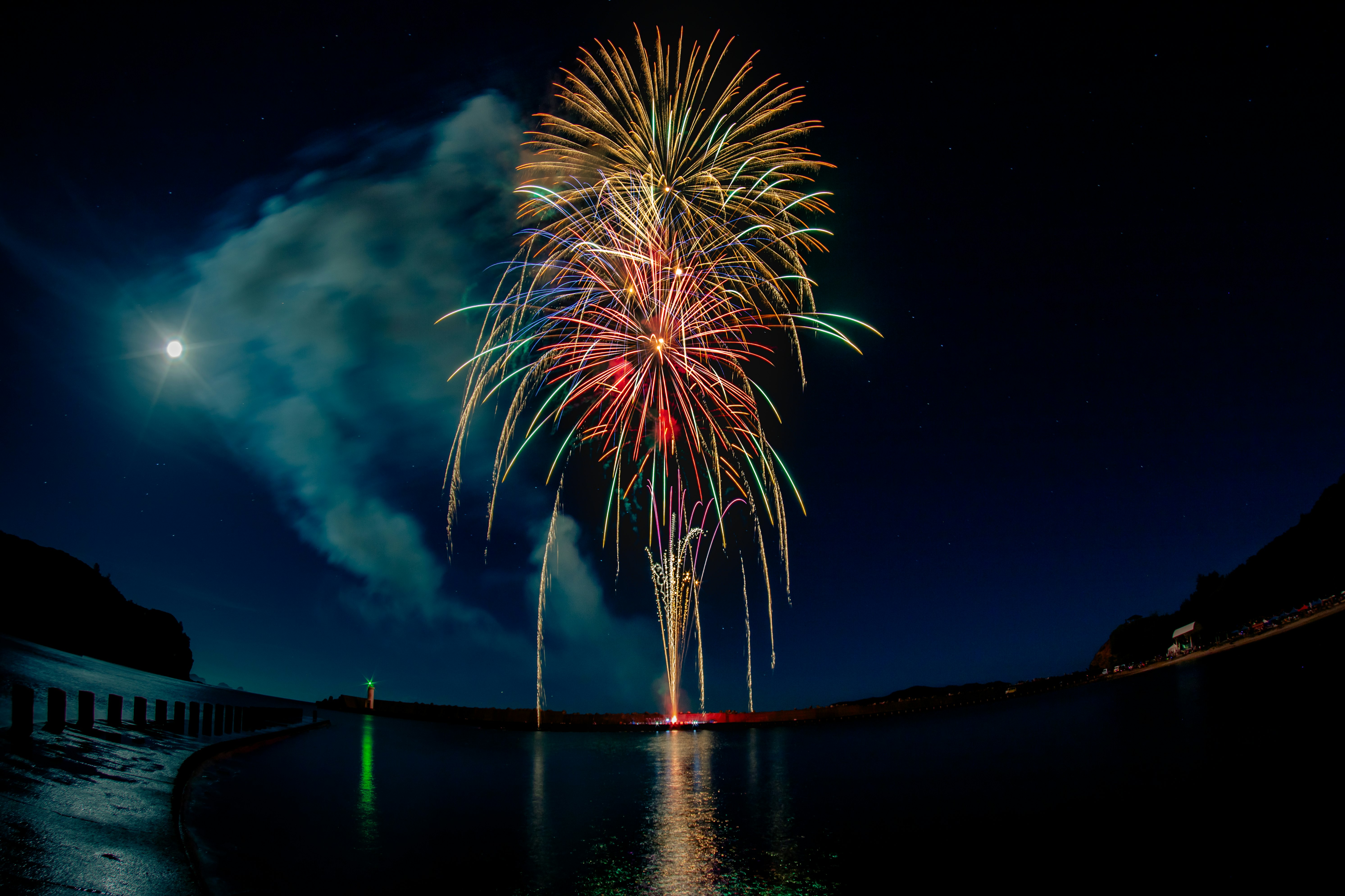 fuegos artificiales reflejados en un lago de noche