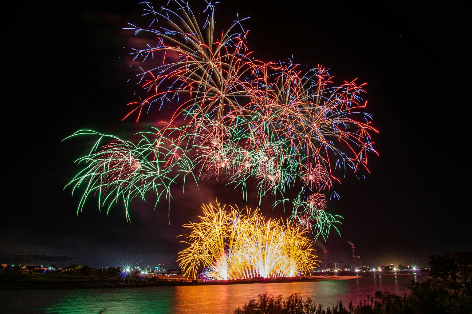 Colorful fireworks display lighting up the night sky reflections on the water