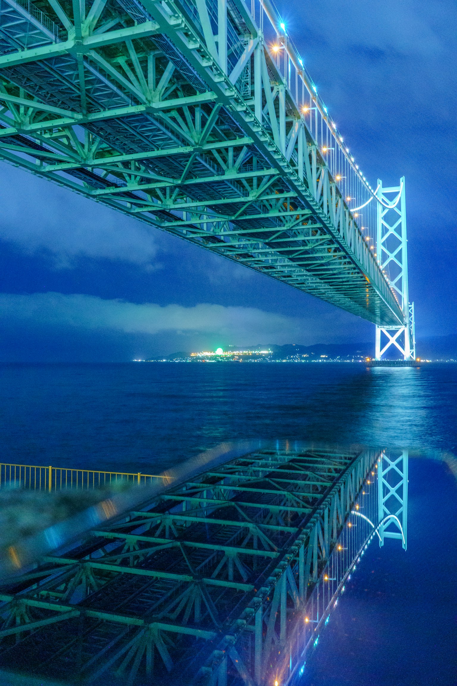 青い夜空の下に広がる橋の美しい反射が水面に映る