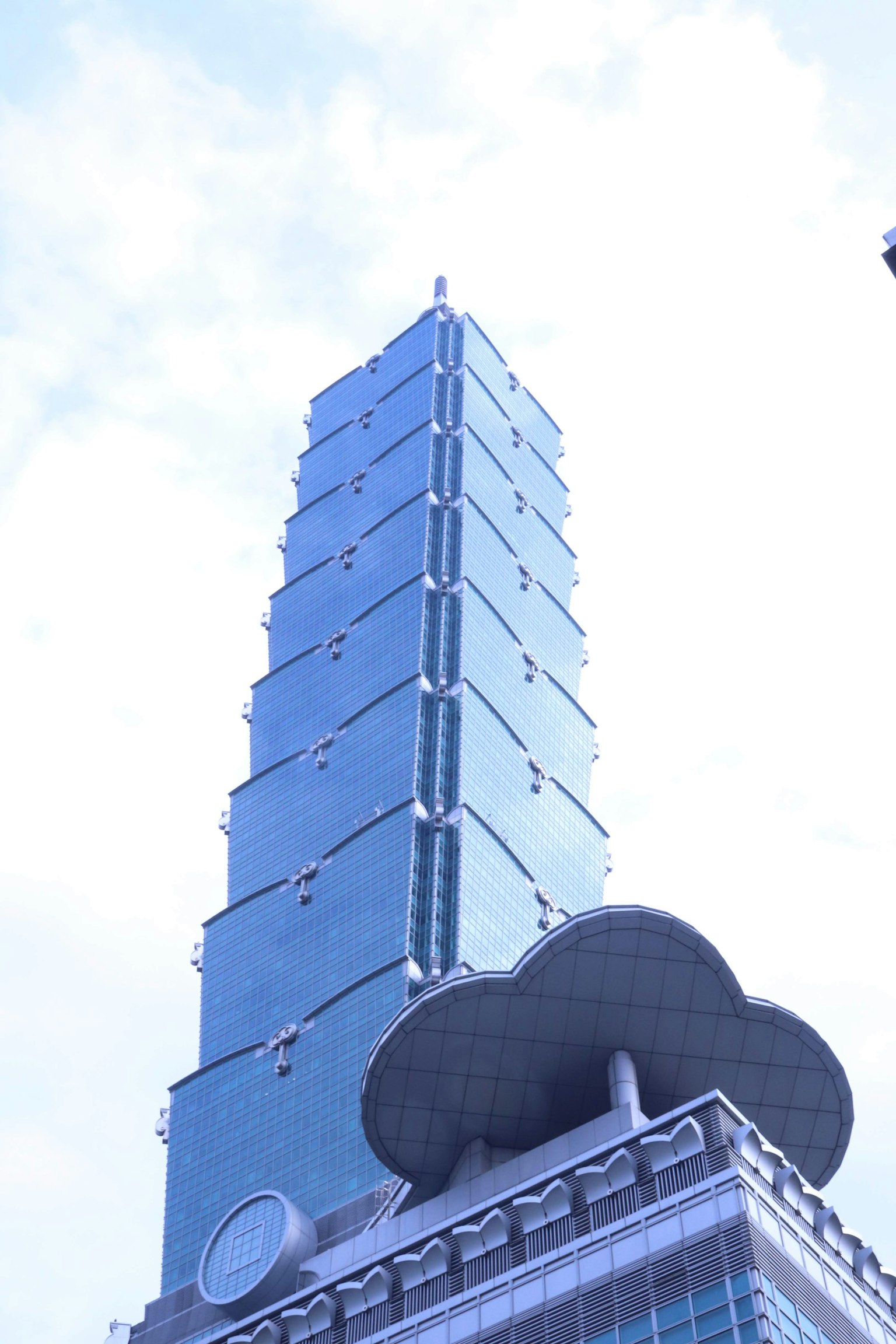 台北101摩天大楼顶部在蓝天下闪耀的图像