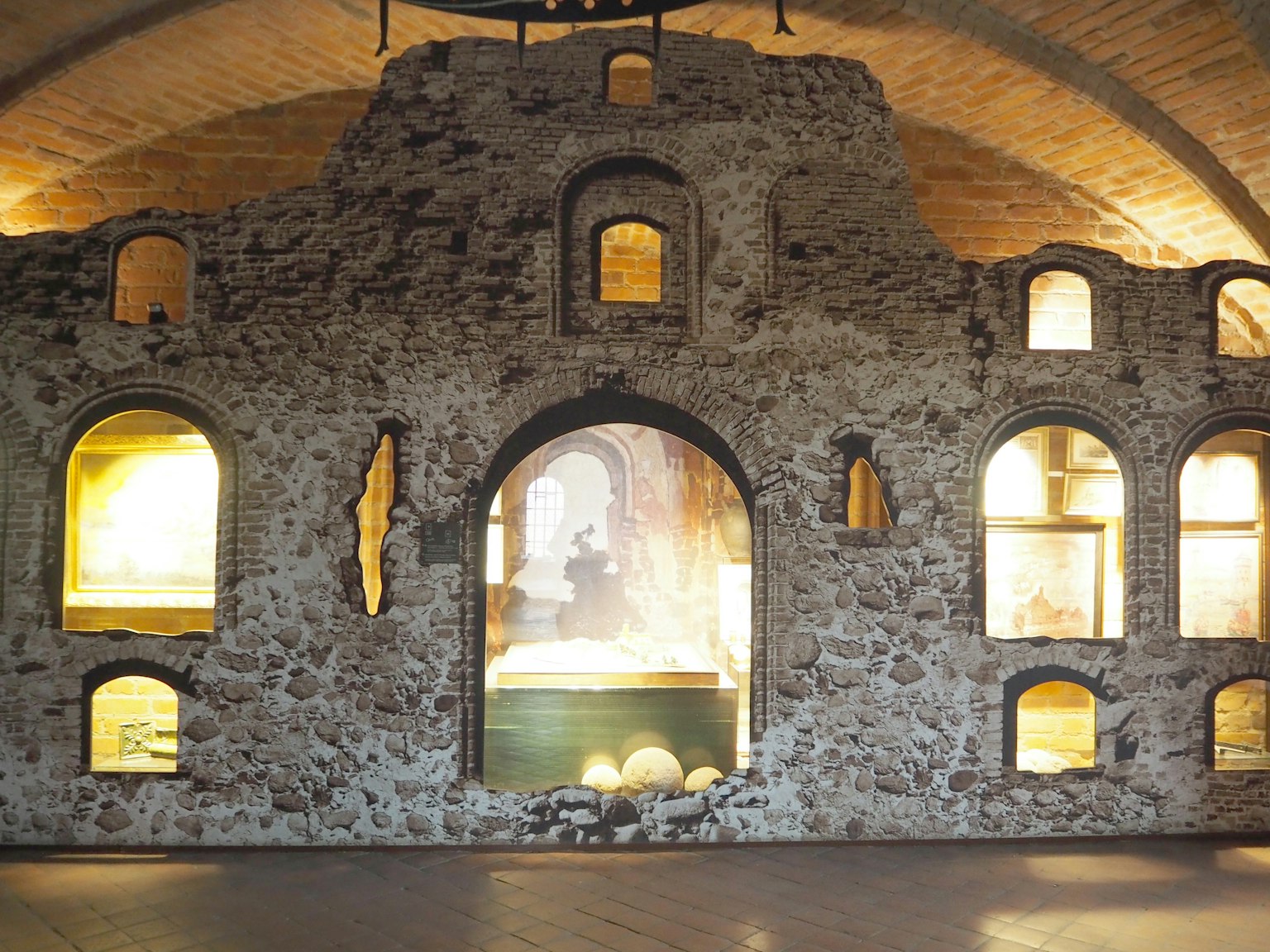 Photo d'un espace intérieur avec un vieux mur en pierre et des fenêtres en arc