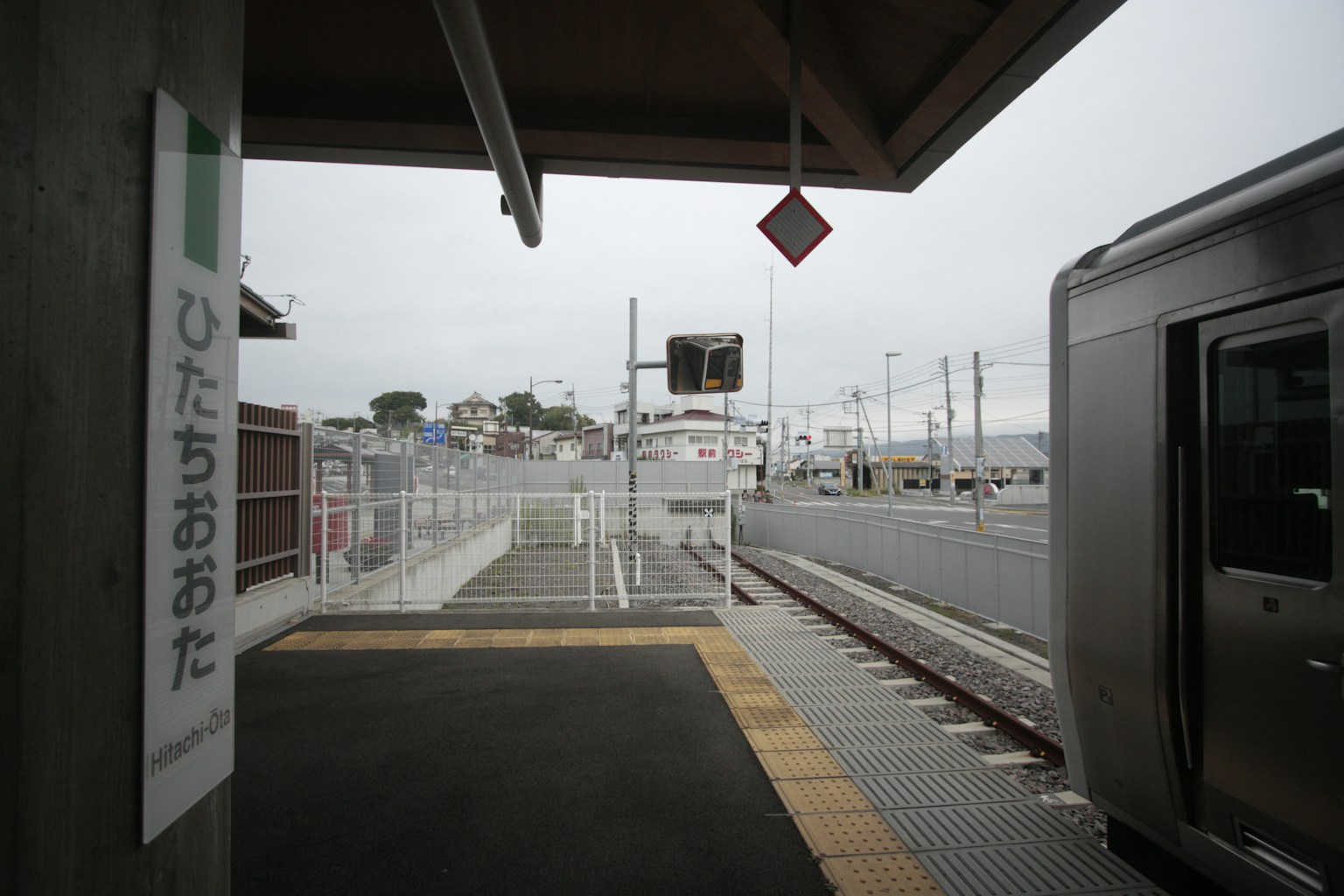 Blick auf den Bahnsteig der Station Hitachi-Oota mit Zug und Beschilderung