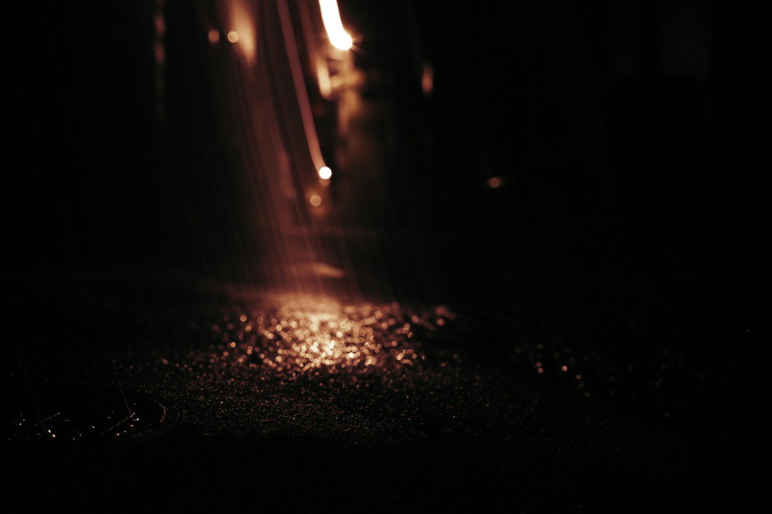 Partikel cahaya dan tetesan air yang memantul di latar belakang gelap