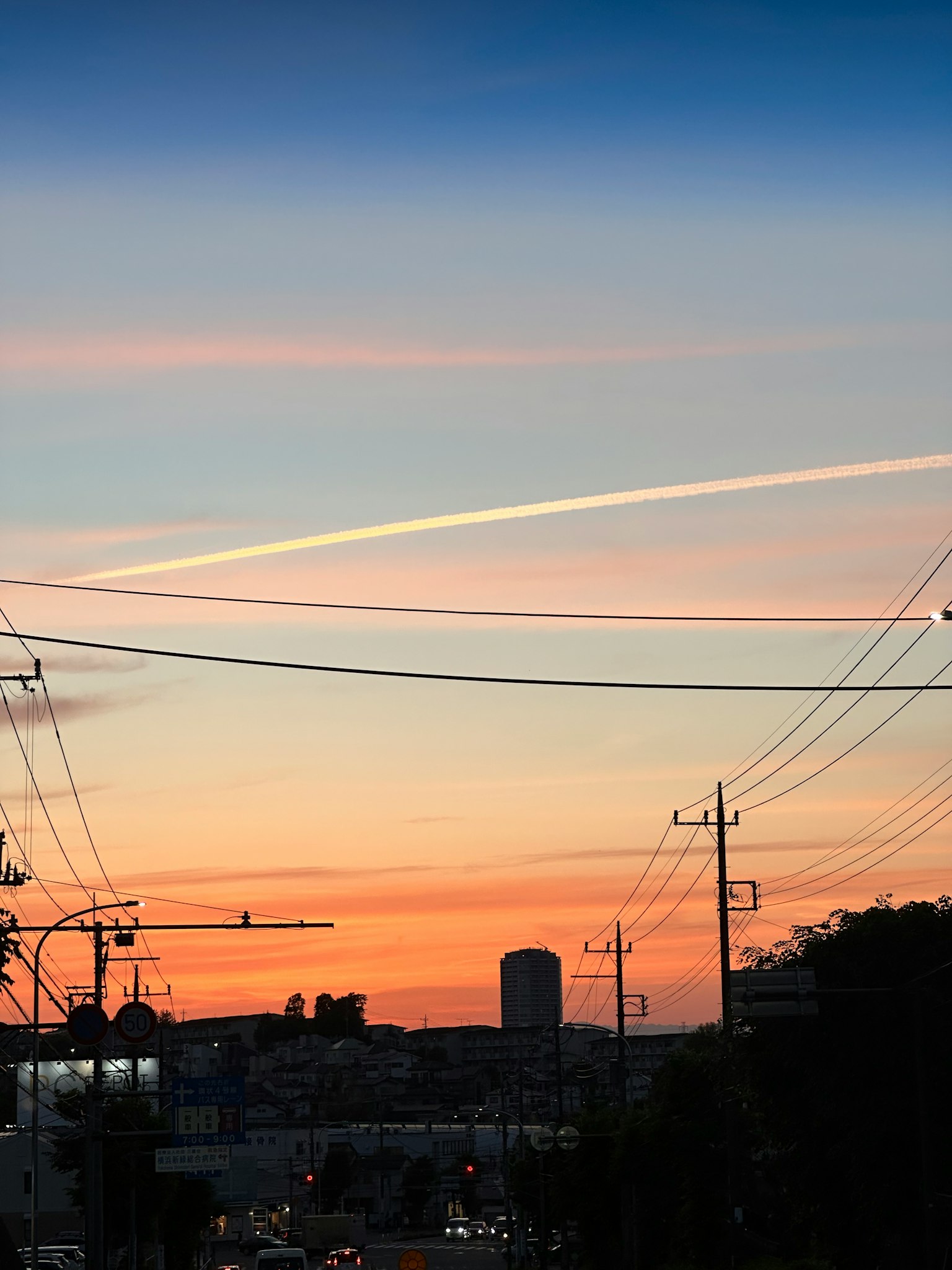 Ciel au coucher du soleil avec des lignes électriques et une silhouette urbaine