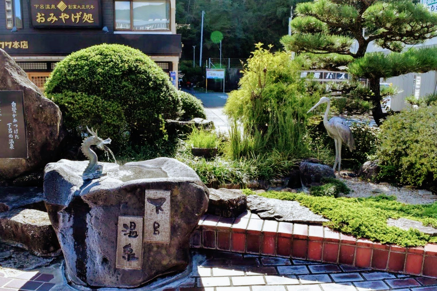 Jardín japonés con un cuenco de agua de piedra y sendero ajardinado