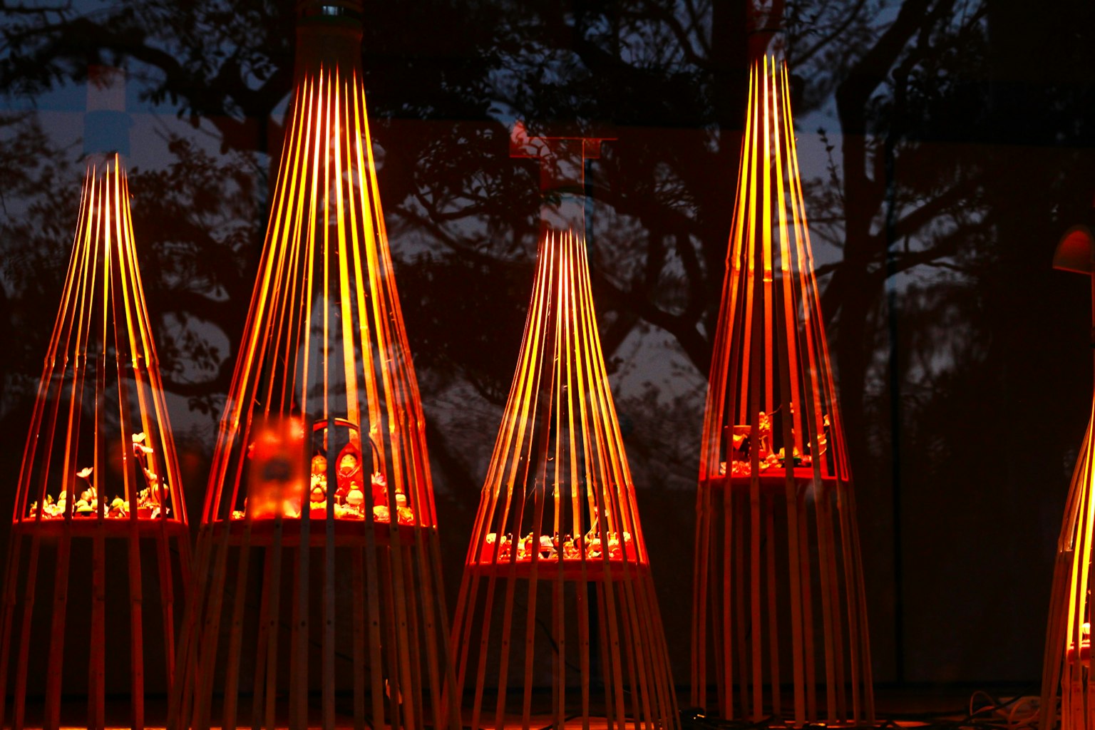 Objets en bois décoratifs illuminés par une lumière rouge disposés en rangée
