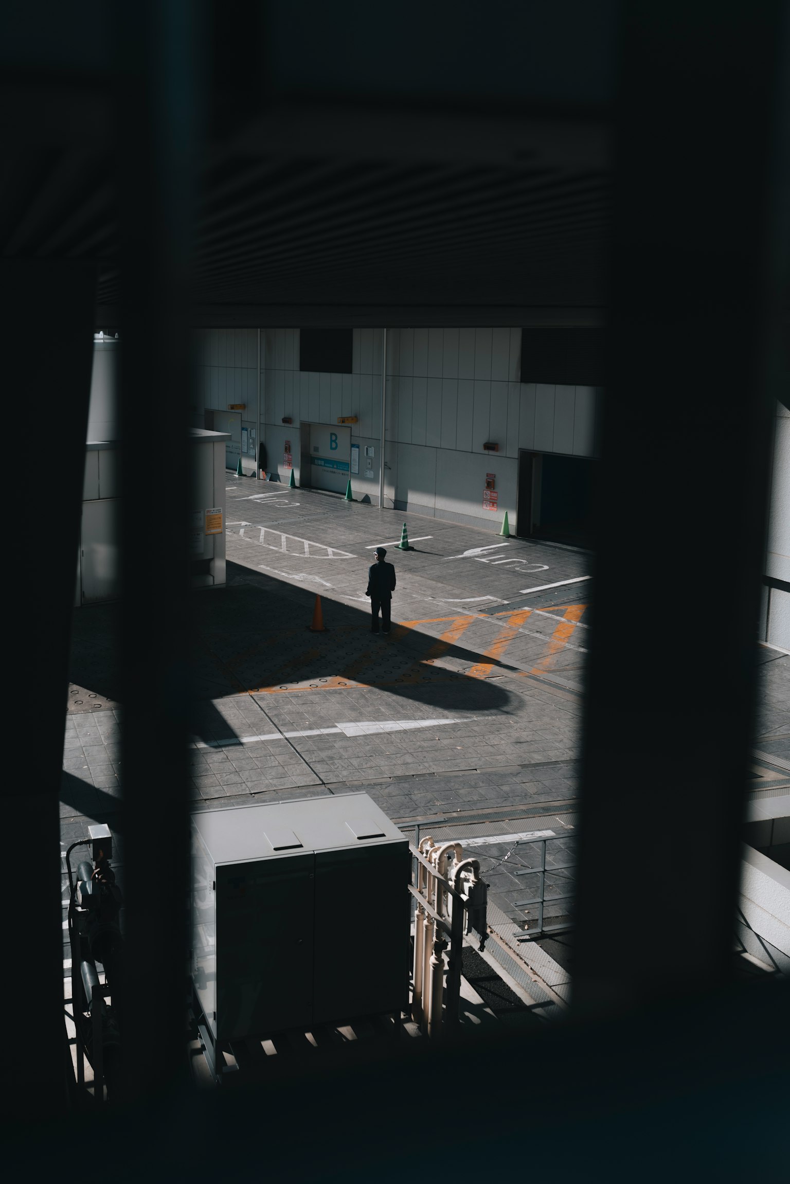 Une silhouette se tenant dans des ombres avec un espace urbain environnant