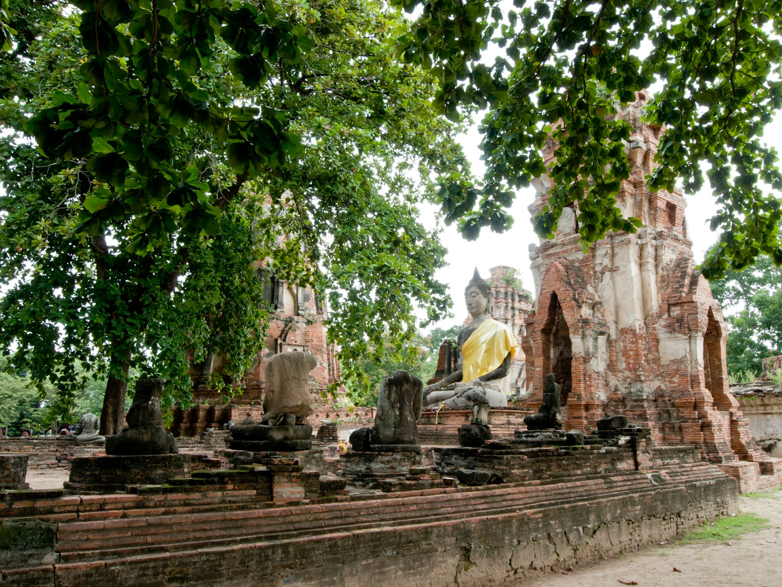 Rovine di un antico tempio con una grande statua di Buddha in un paesaggio sereno
