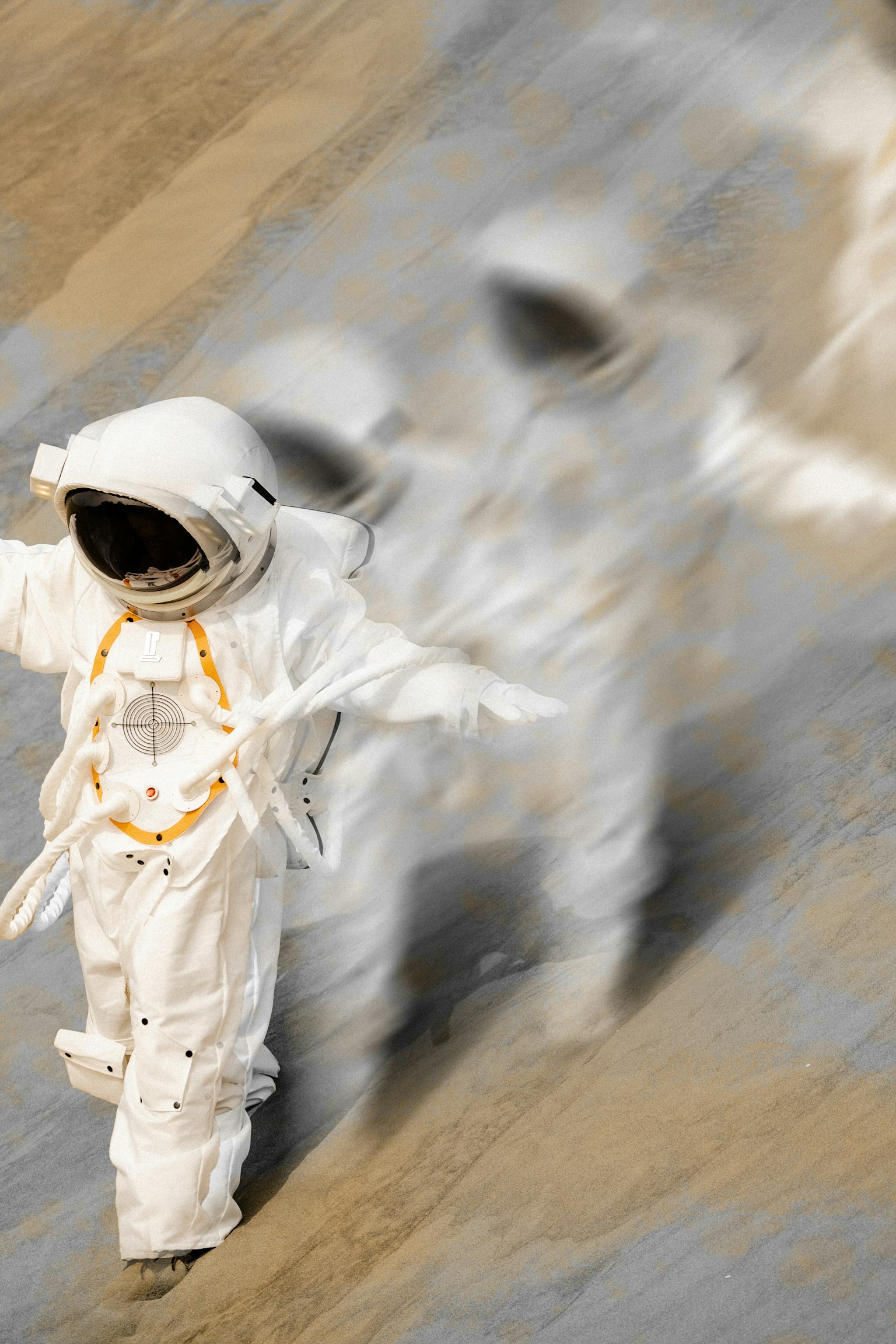 우주복을 입은 우주비행사가 앞으로 걷고 있으며 뒤에 흐릿한 모습이 보인다