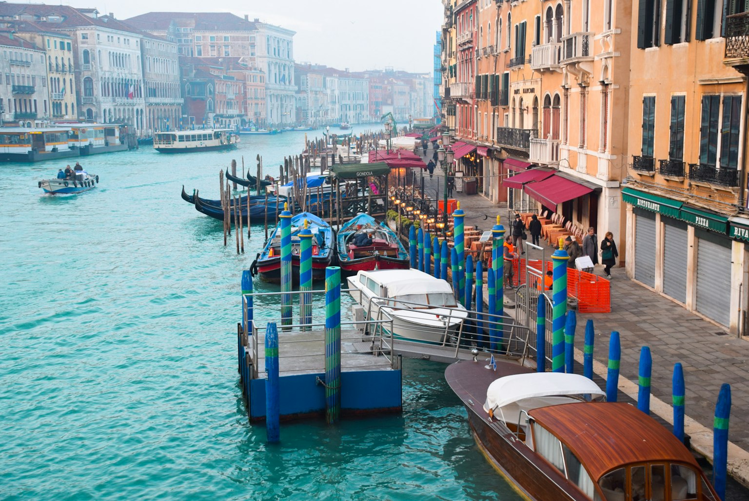 Barche colorate e molo per taxi acqueo lungo i canali di Venezia