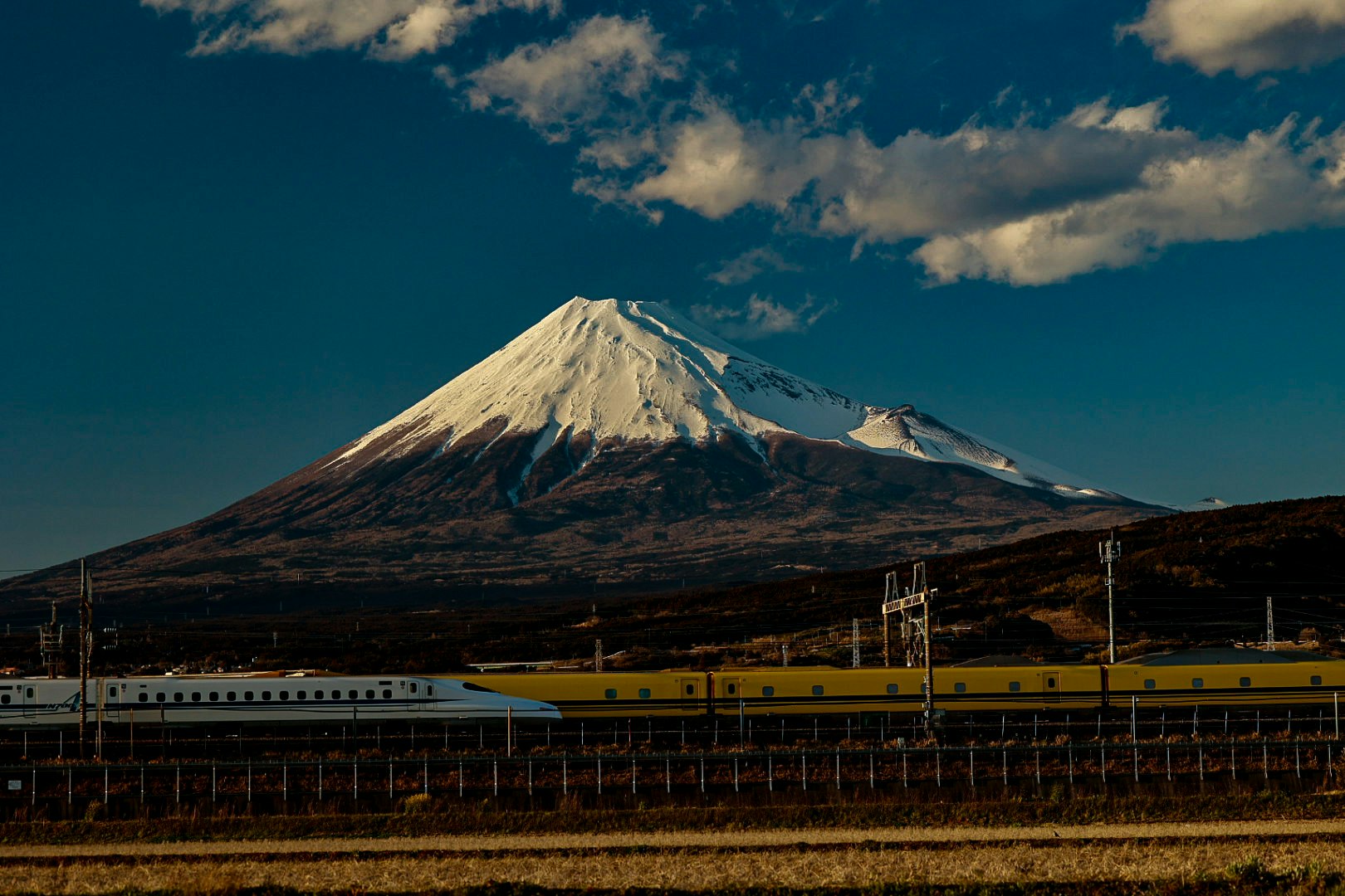 train with Mount Fuji in the distance over rural landscape