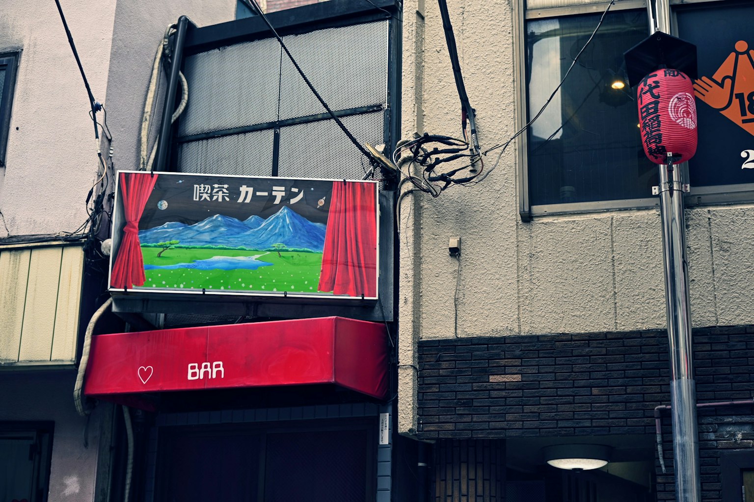 ภายนอกของร้านค้าที่มีป้ายสีแดงและภาพทิวทัศน์