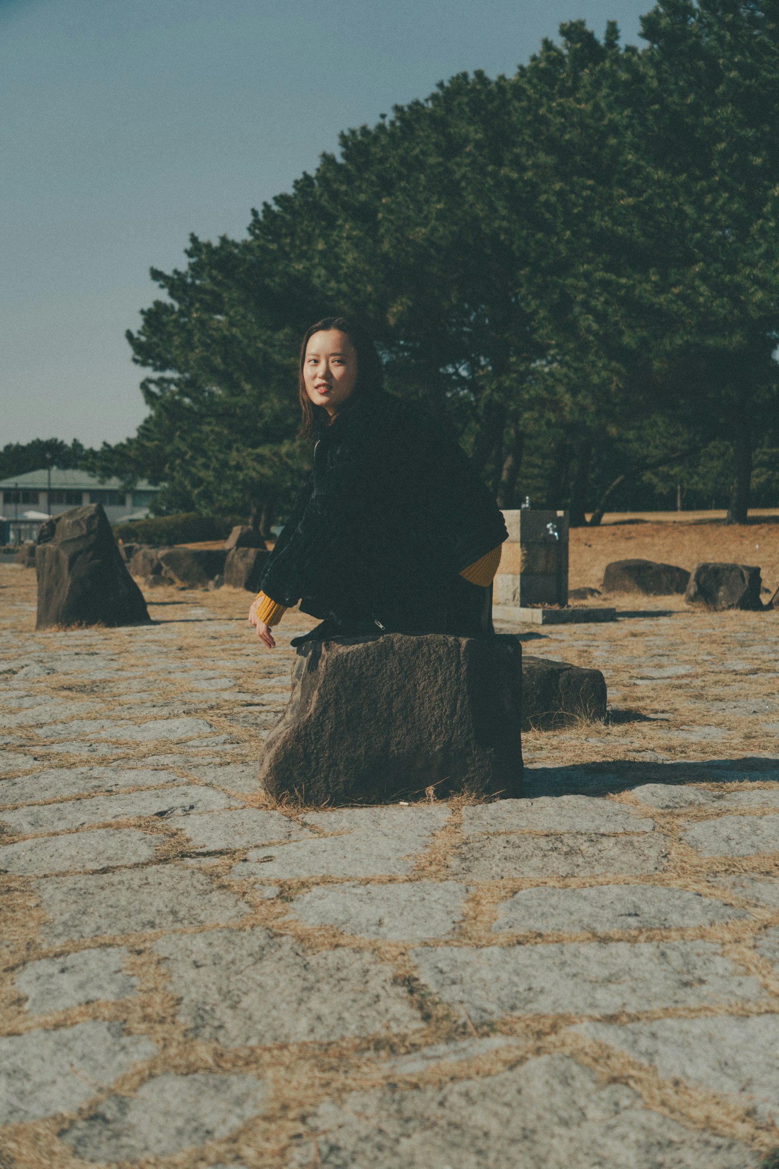 Woman sitting on a stone in a natural setting