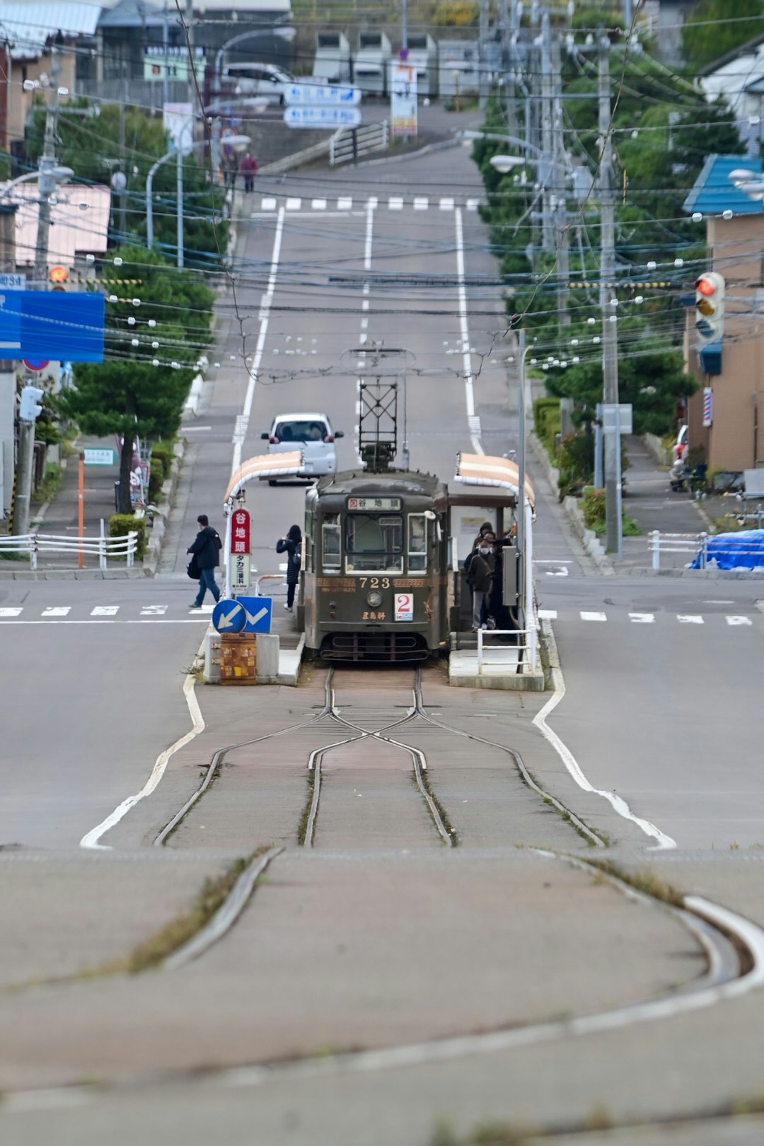 踏切のある市街地で走る路面電車のある風景