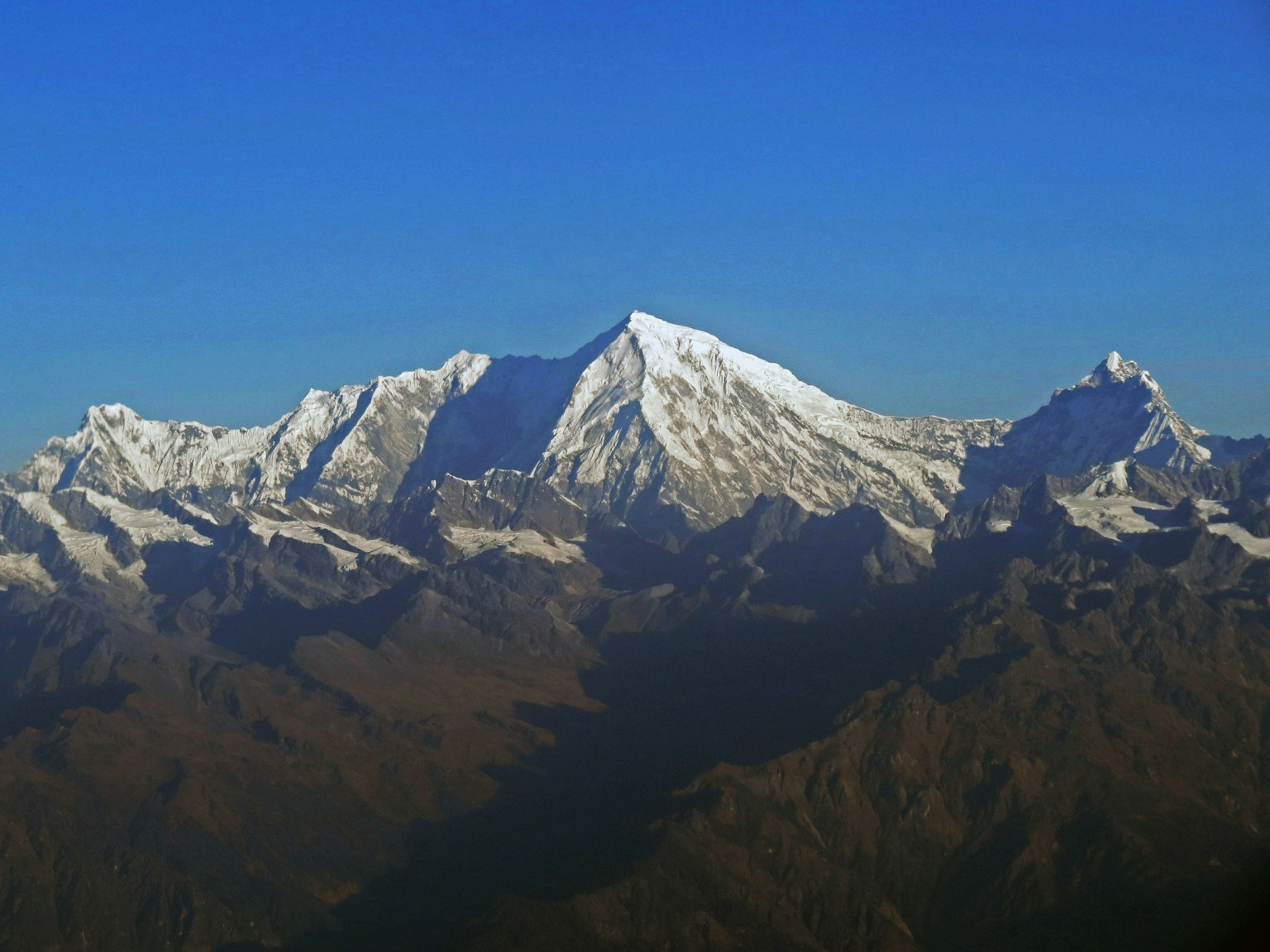 Gunung bersalju di bawah langit biru yang cerah