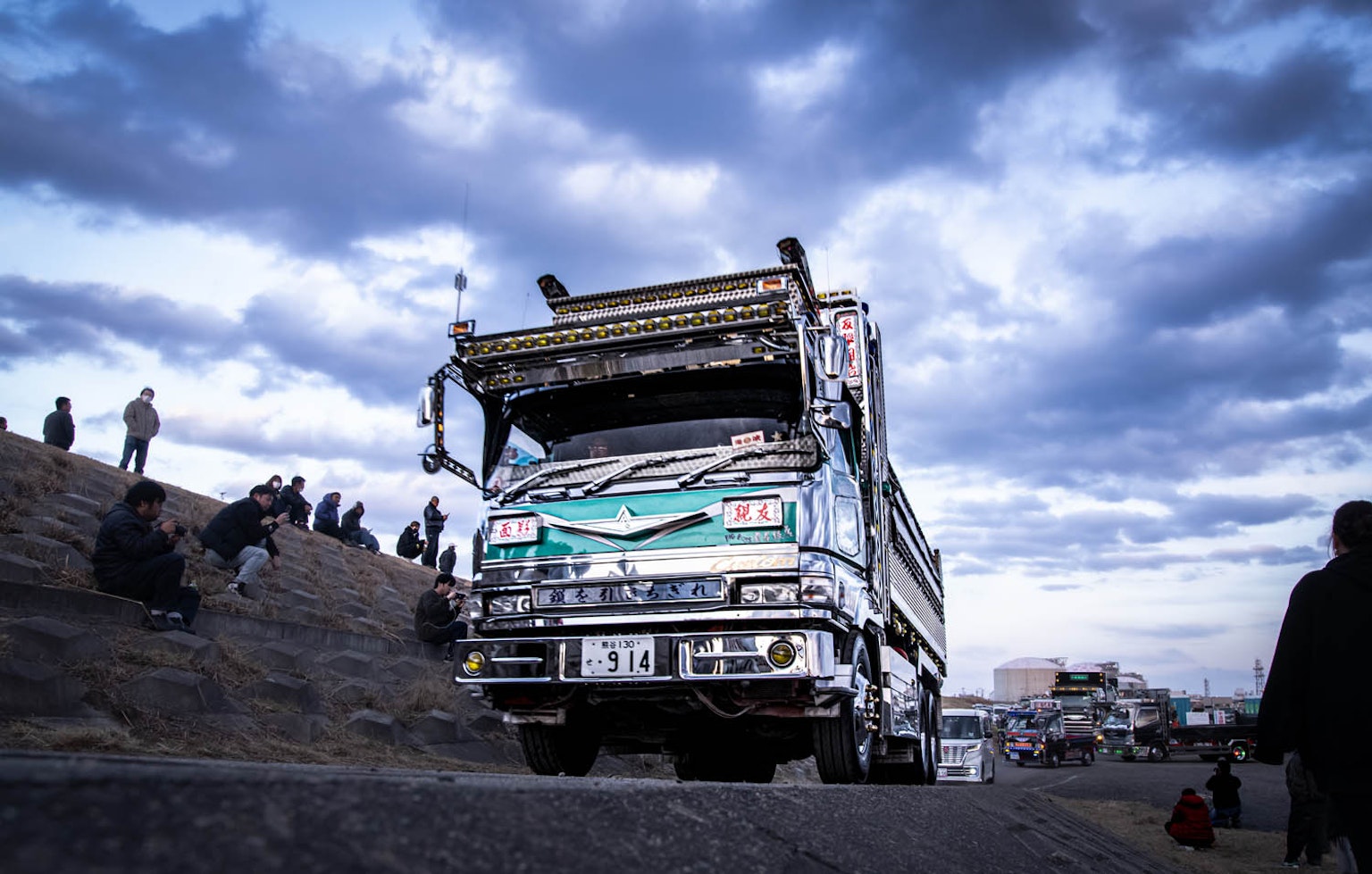 Un camion sur la route avec des spectateurs regardant