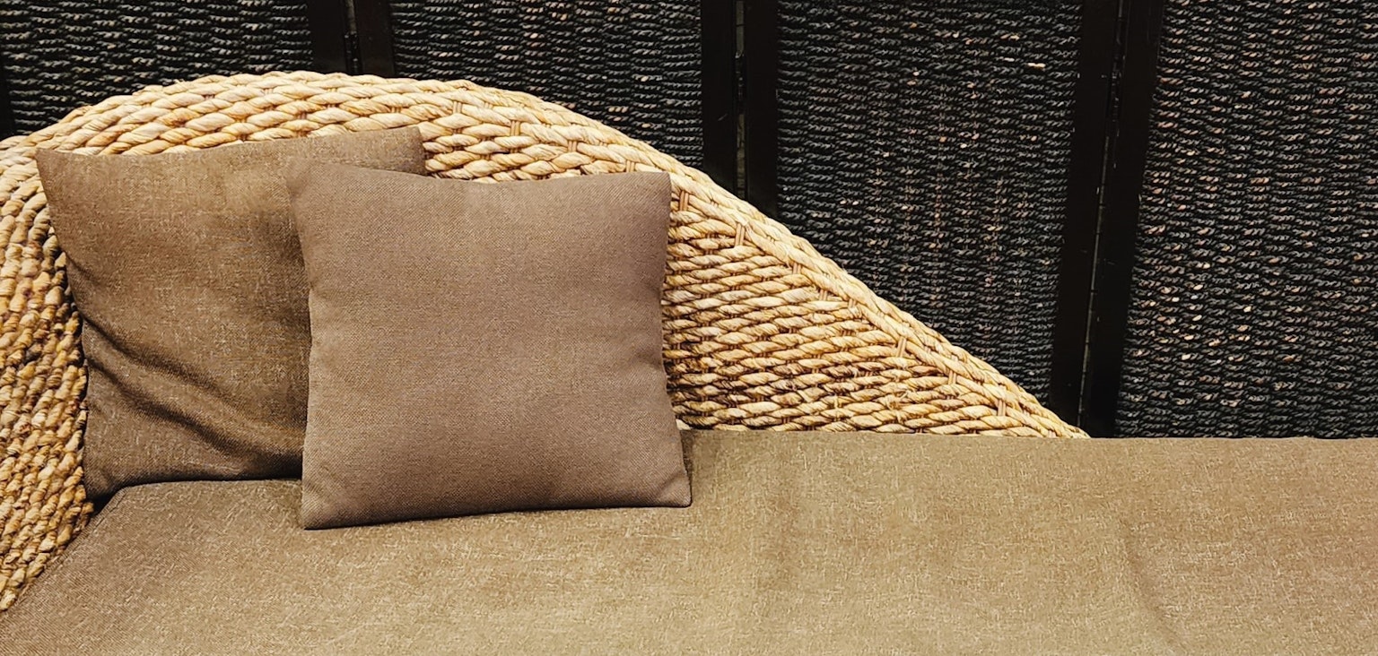 Một phần của ghế sofa mây với một cái gối nâu