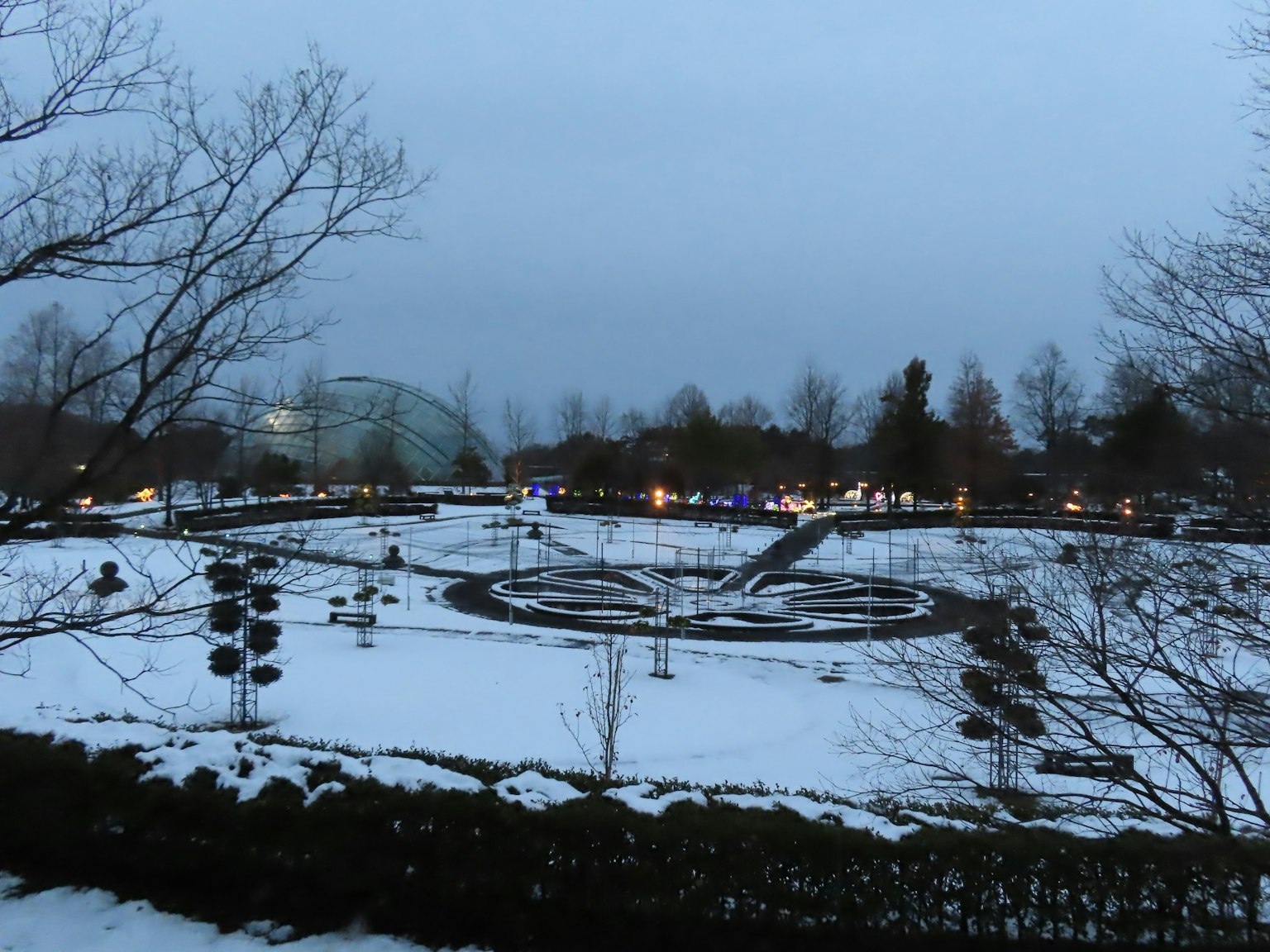 Paesaggio del parco coperto di neve con luci serali