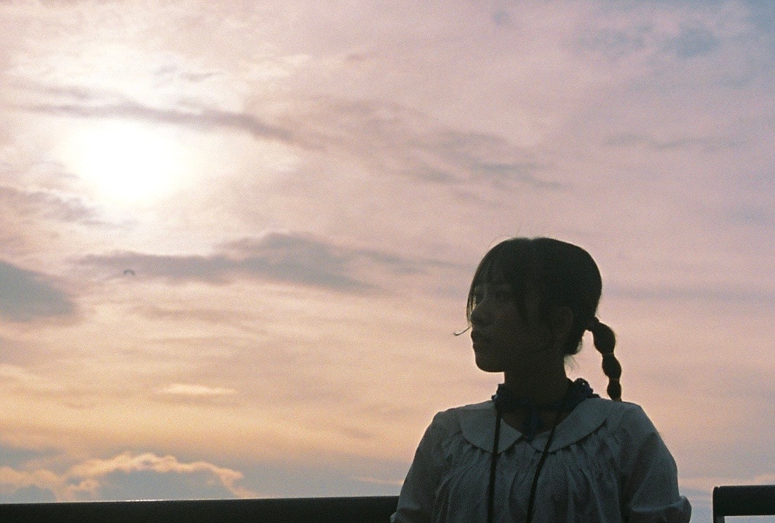 夕暮れの空を見上げる人物のシルエット