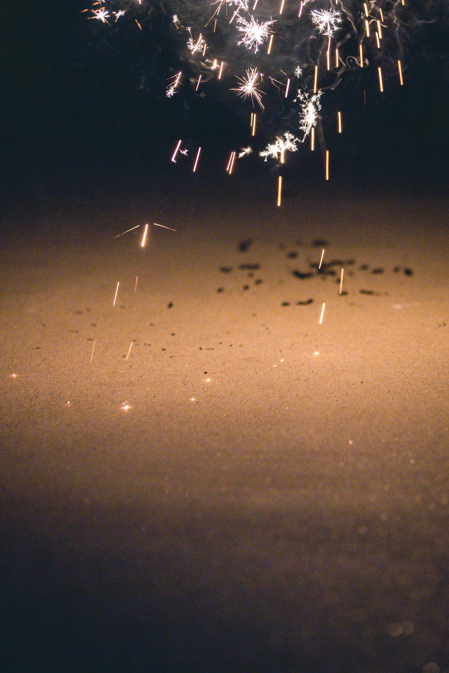 Des étincelles ressemblant à des feux d'artifice tombant au sol la nuit
