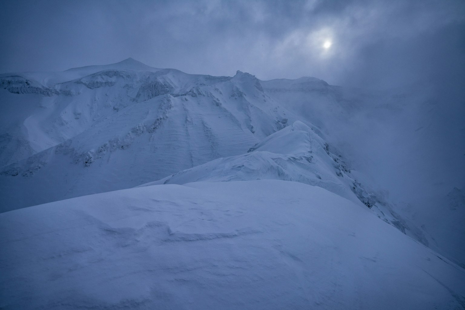 Paesaggio montano innevato con cielo nuvoloso