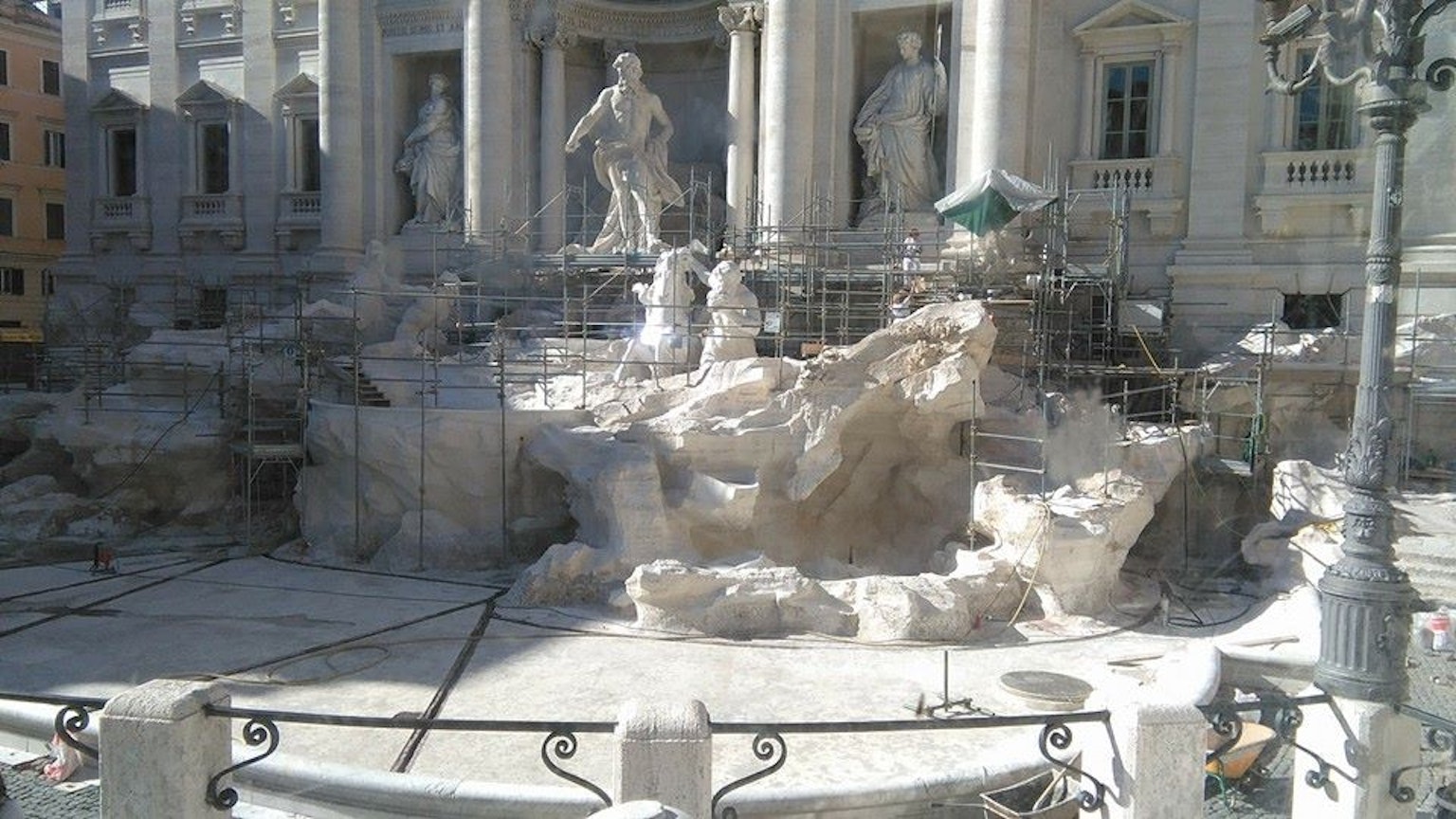 Lavori di restauro alla fontana di Trevi con sculture e ponteggi visibili