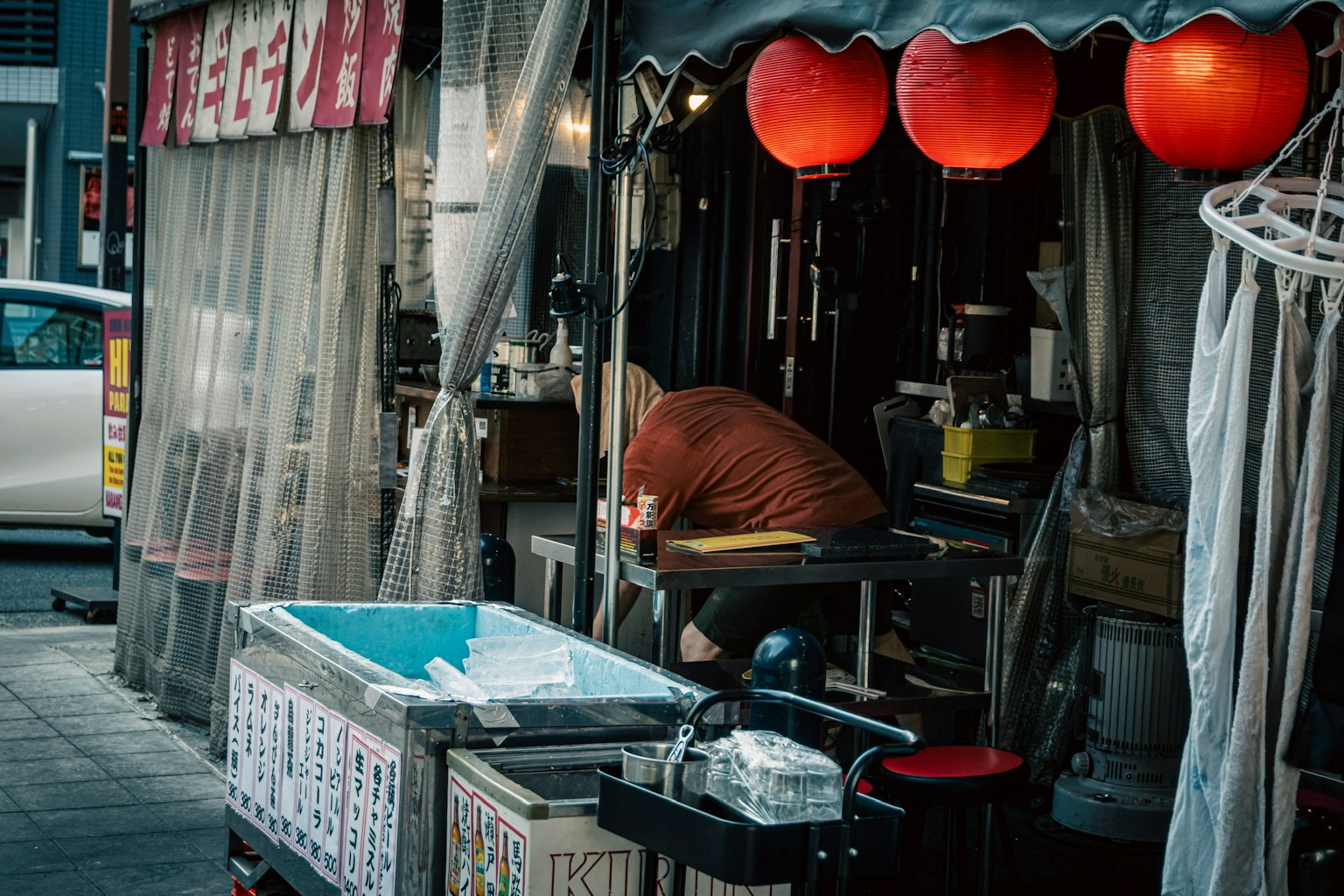 Mann, der vor einem Essensstand mit roten Laternen arbeitet