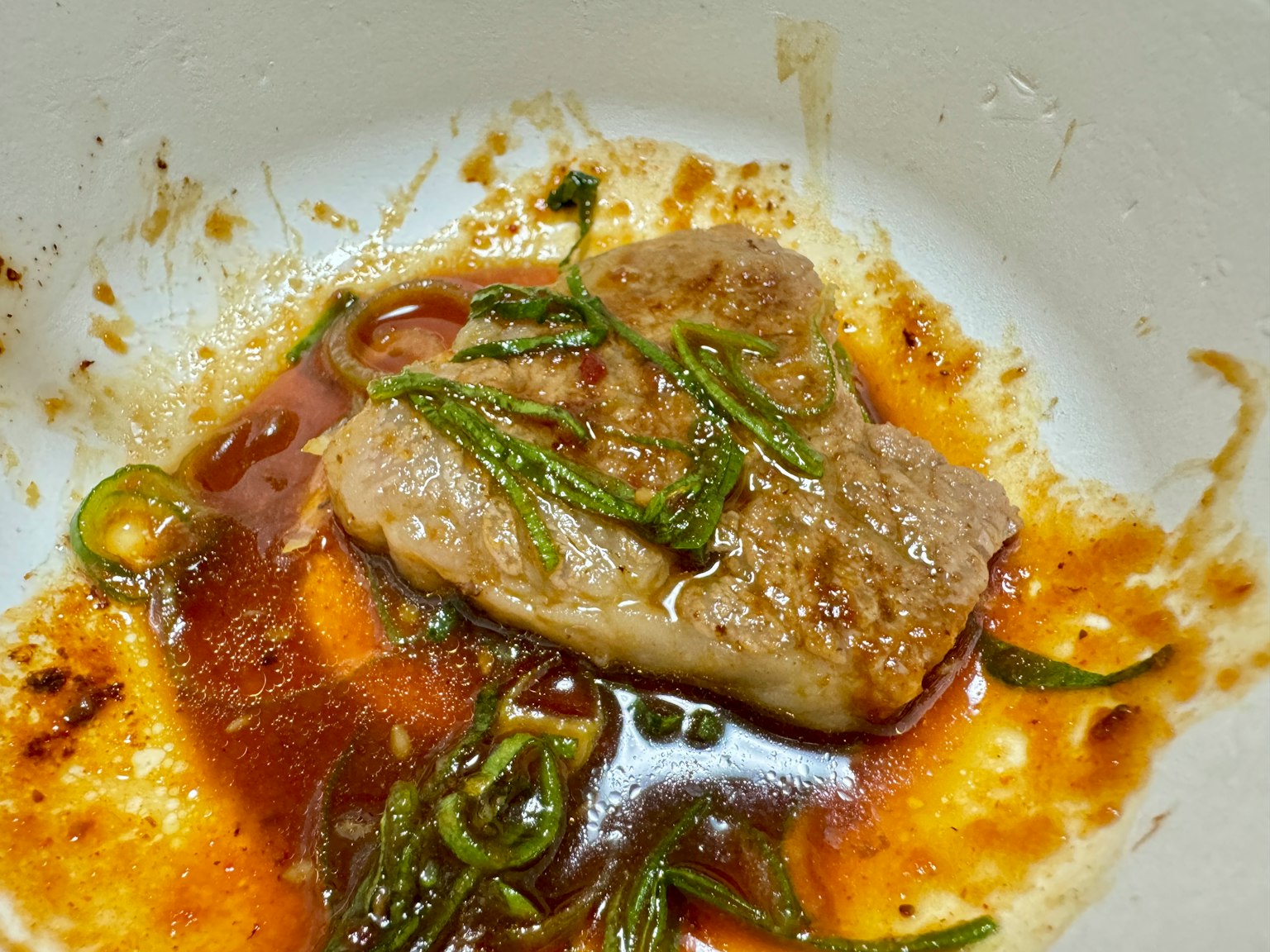 Pezzetto di carne in una ciotola con salsa di erbe verdi