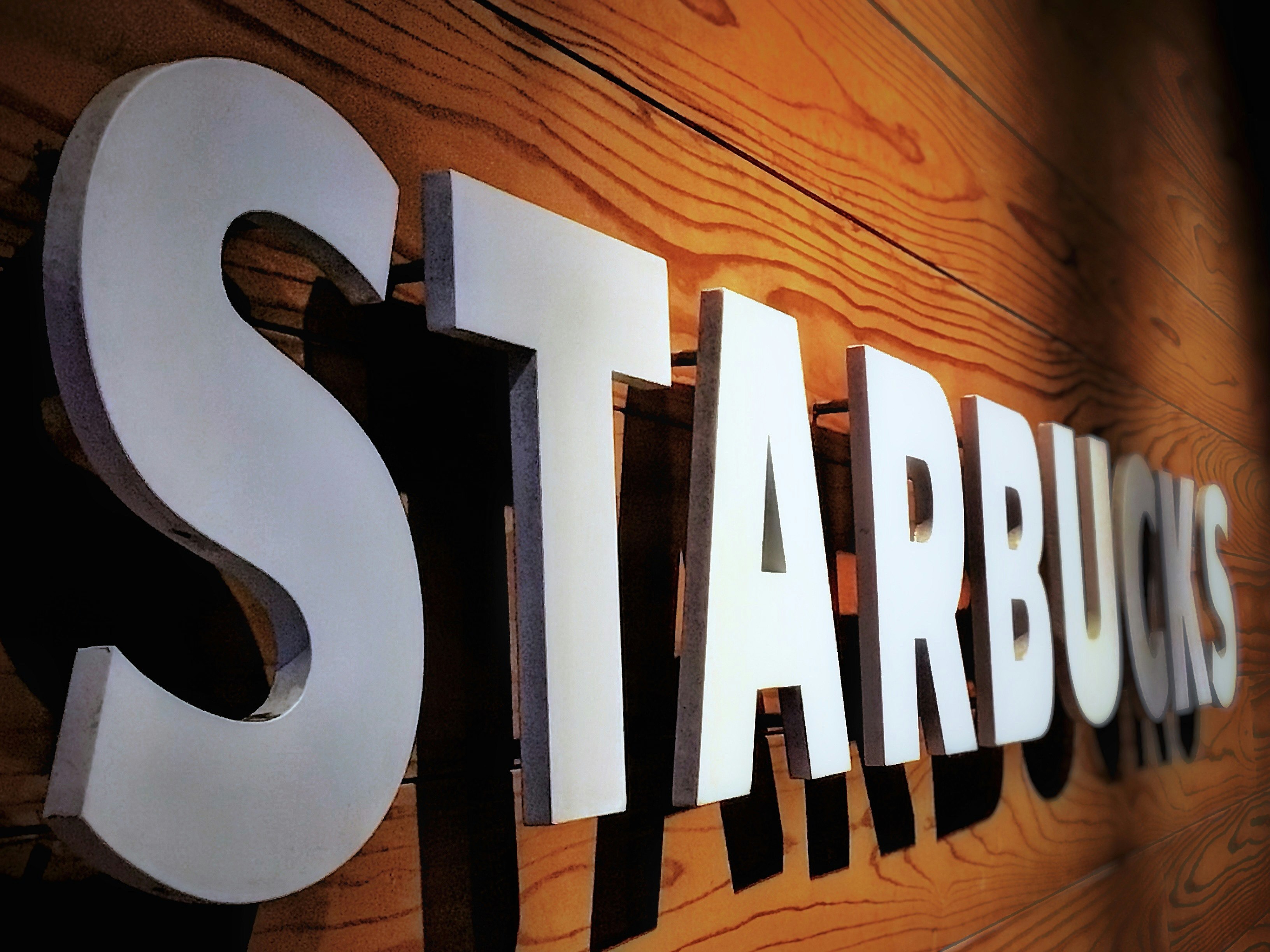 近所のスタバの店名ロゴが壁に掲げられた店先