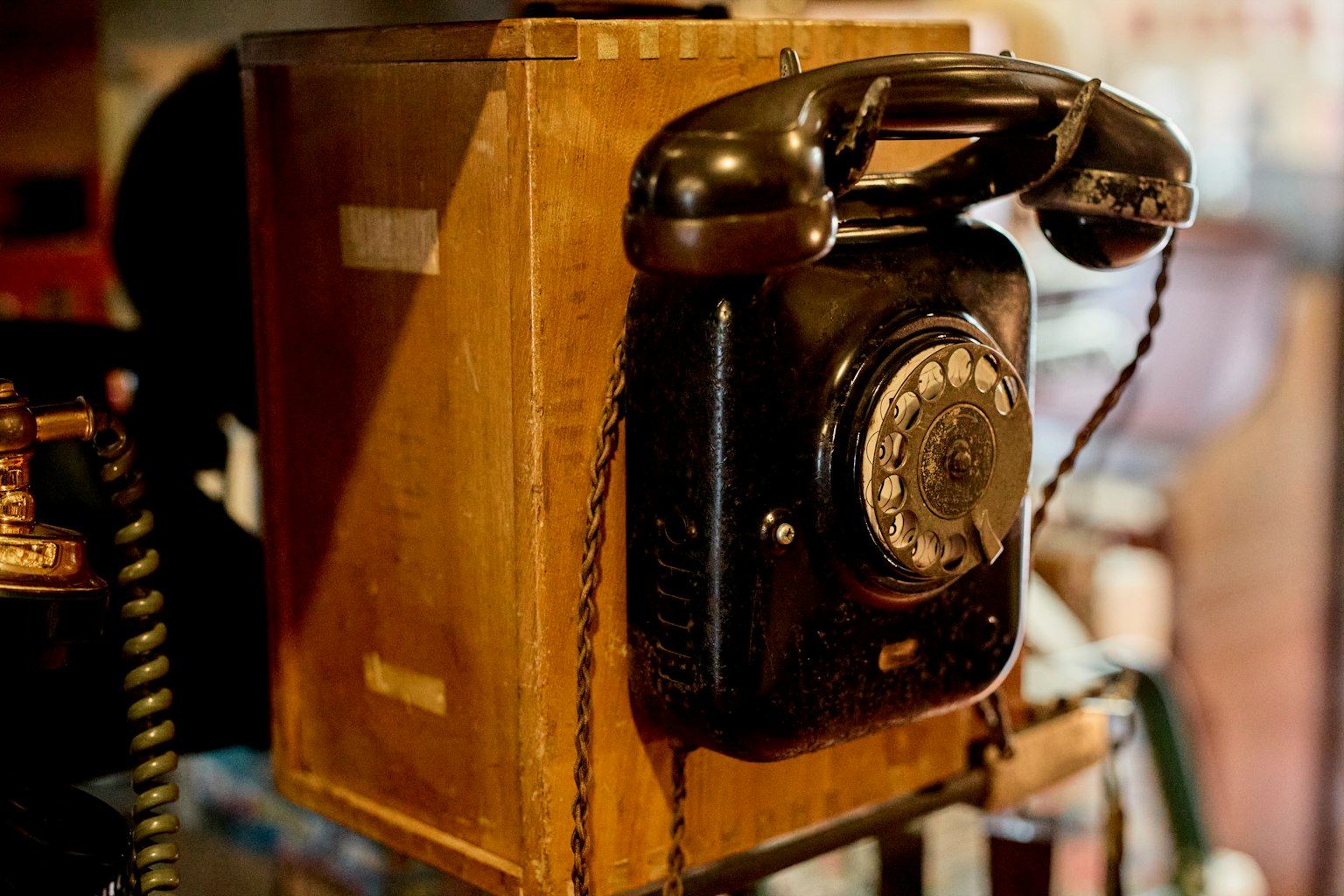 Imagen de un antiguo teléfono negro montado en una caja de madera