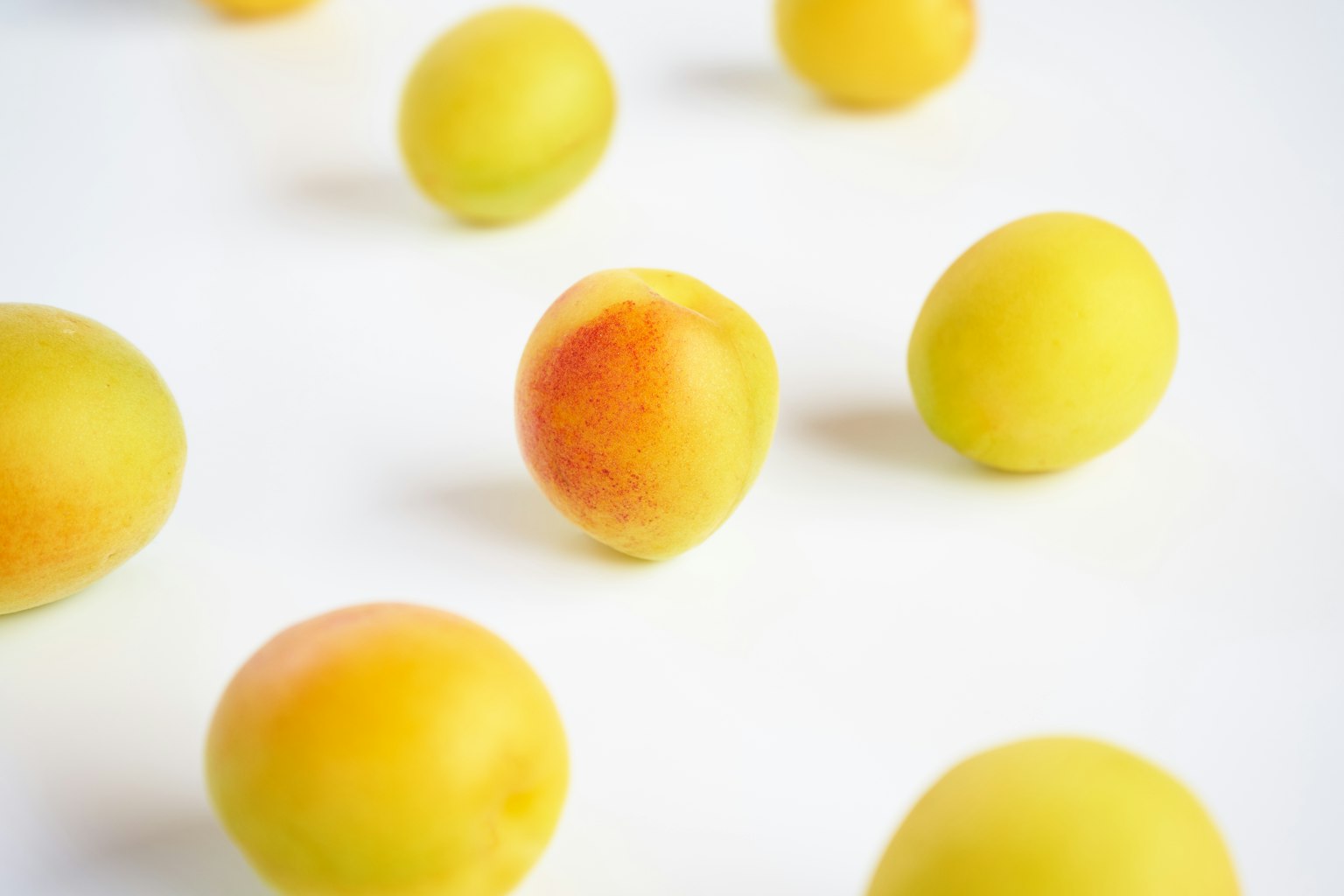 Frutas amarillas brillantes esparcidas sobre un fondo blanco