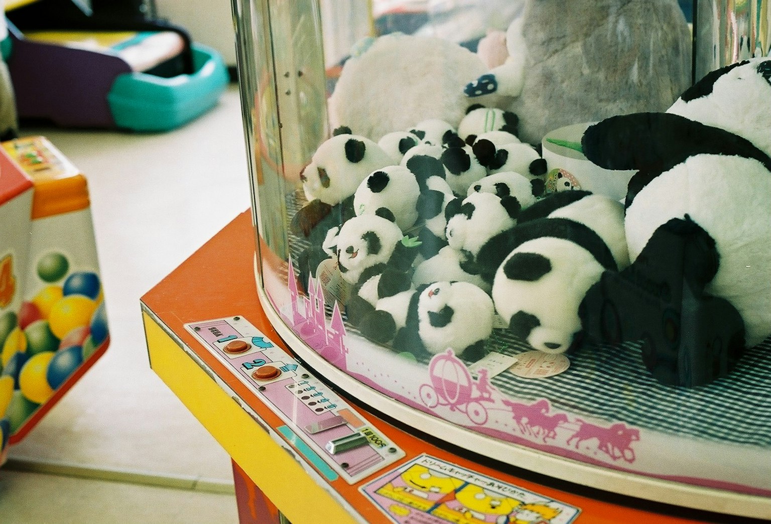 Una varietà di piccoli peluche panda all'interno di una macchina per giochi