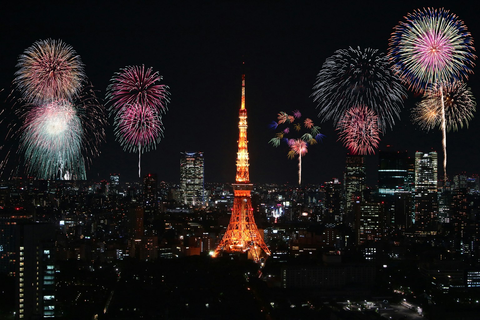 Tour Tokyo illuminée la nuit avec des feux d'artifice colorés explosant dans le ciel