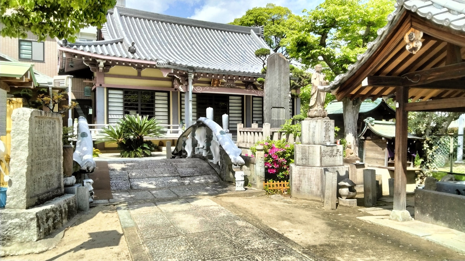 Serene temple scene with visible bridge and stone statues