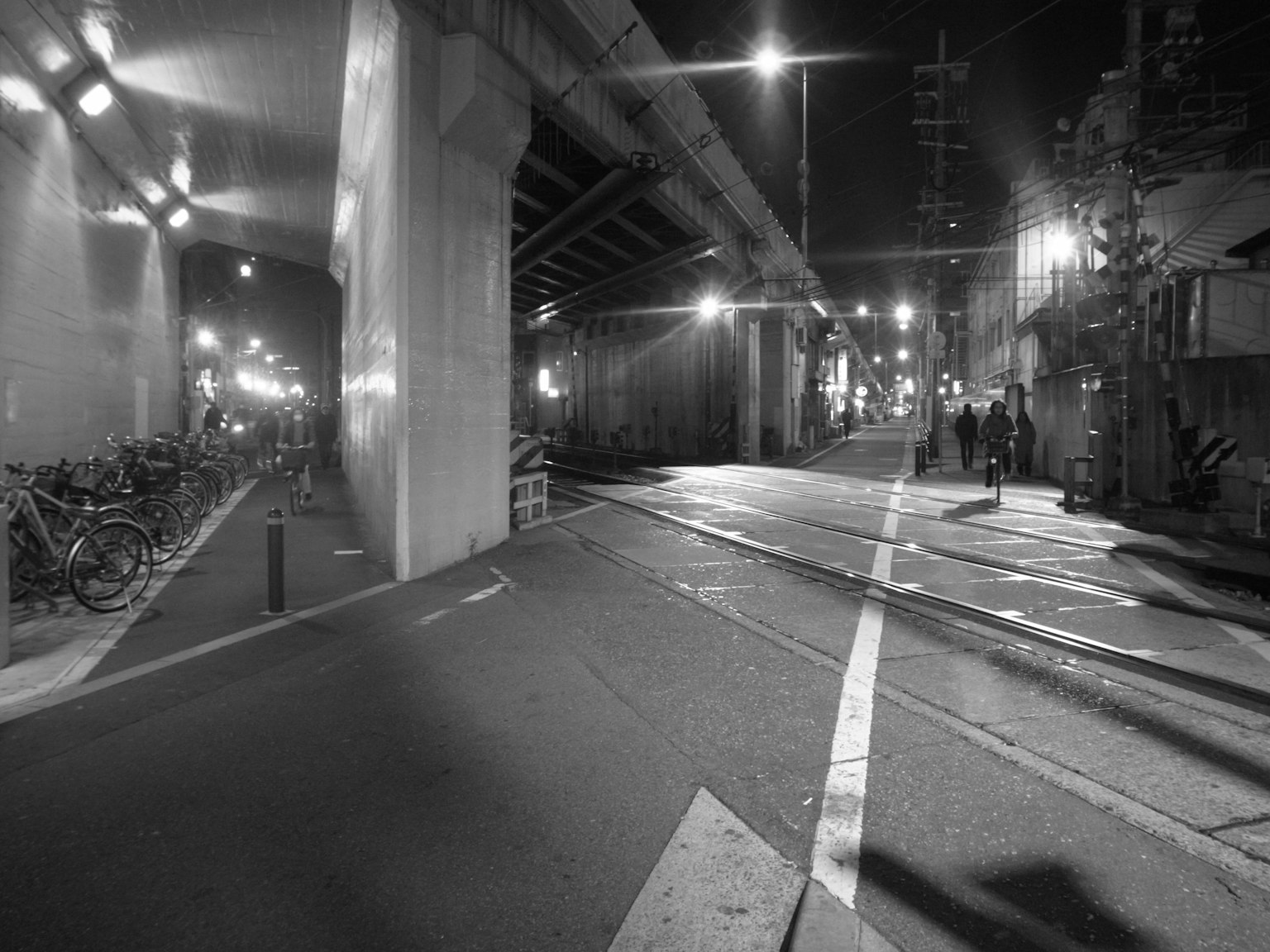 Night urban scene with parked bicycles and road under a bridge