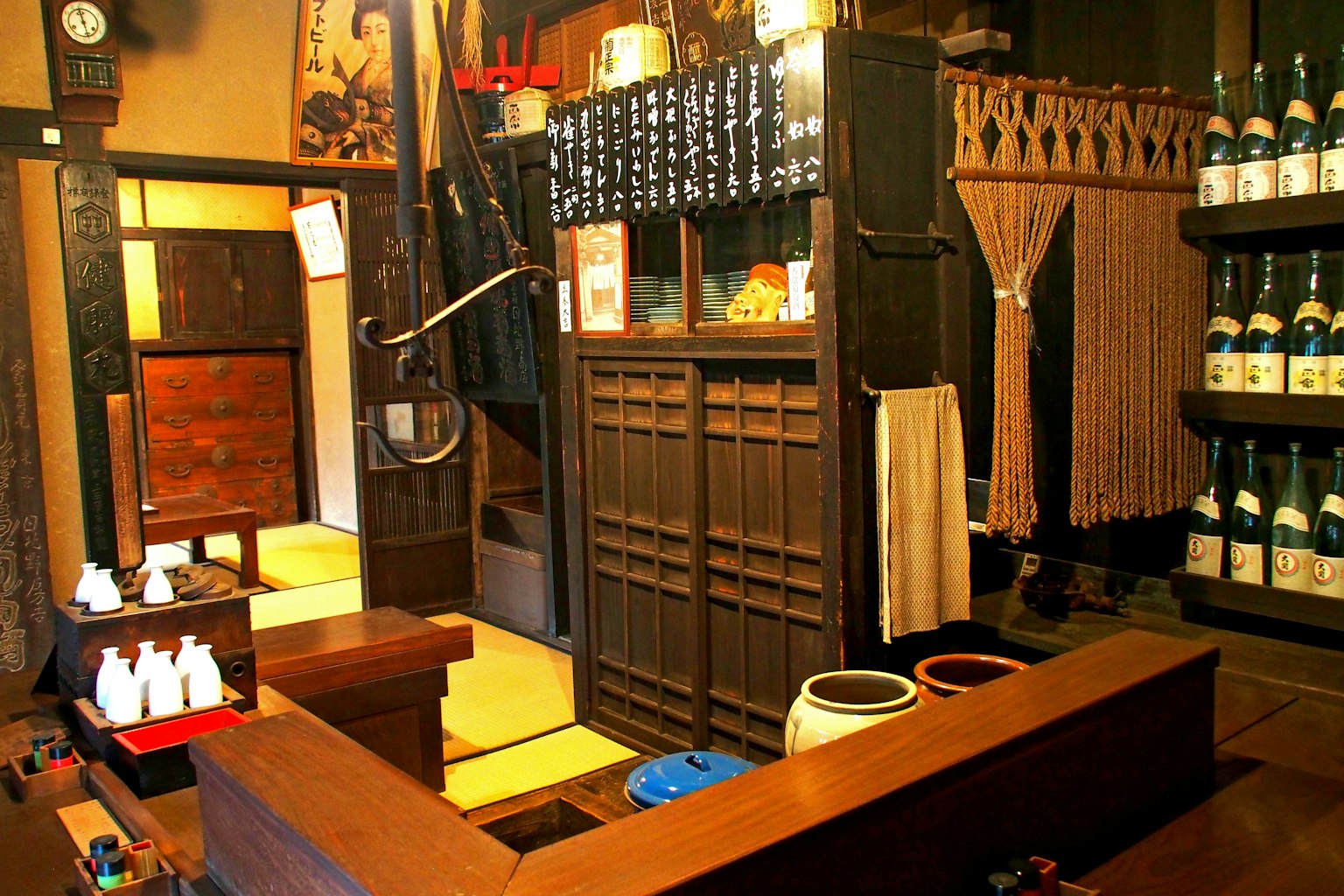 傳統日本居酒屋的內部，木製櫃檯和酒瓶架
