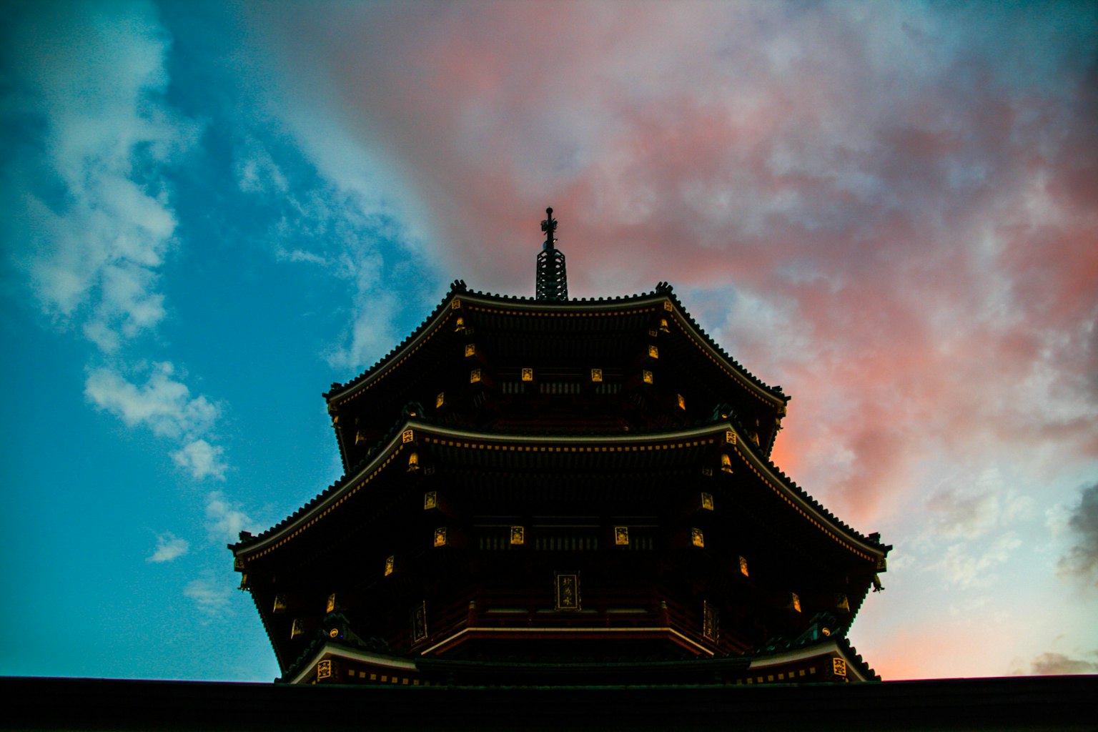 Silhouette d'un temple japonais traditionnel contre un ciel de coucher de soleil