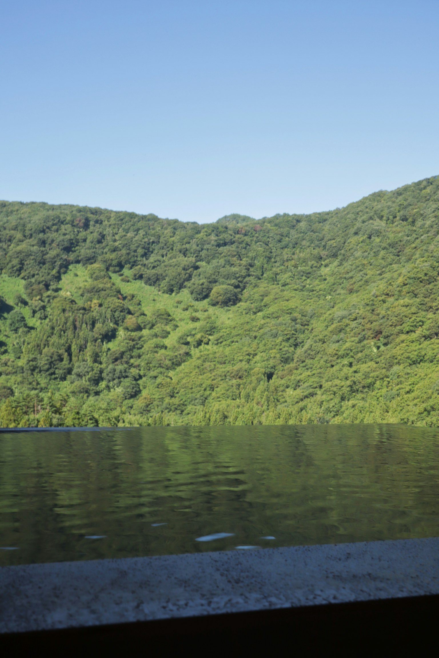 Vue pittoresque de collines verdoyantes reflétées dans une eau calme