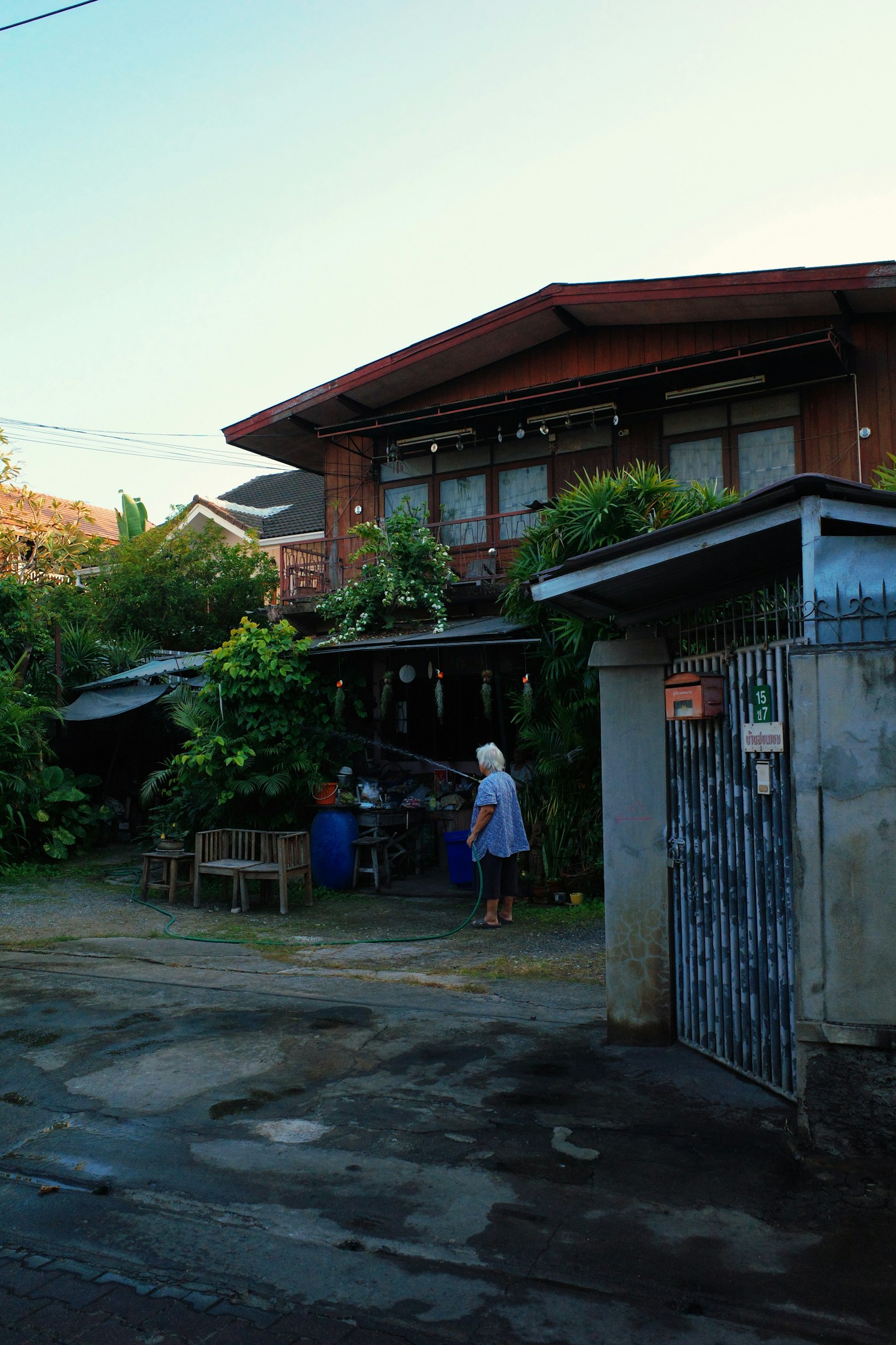 บ้านที่ถูกล้อมรอบด้วยพืชสีเขียวและมีผู้คนอยู่