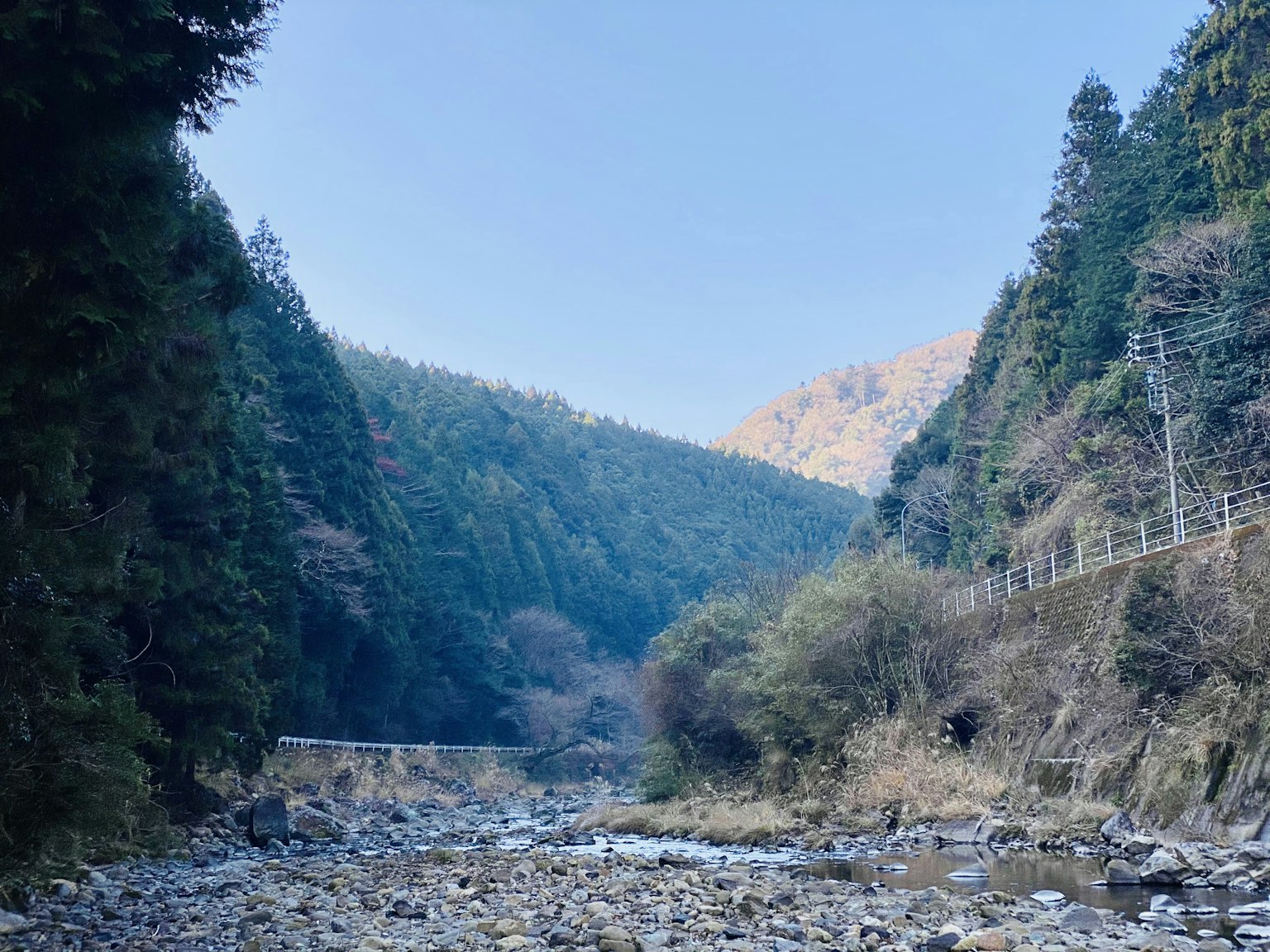 Pemandangan lembah gunung dengan sungai di bawah langit biru