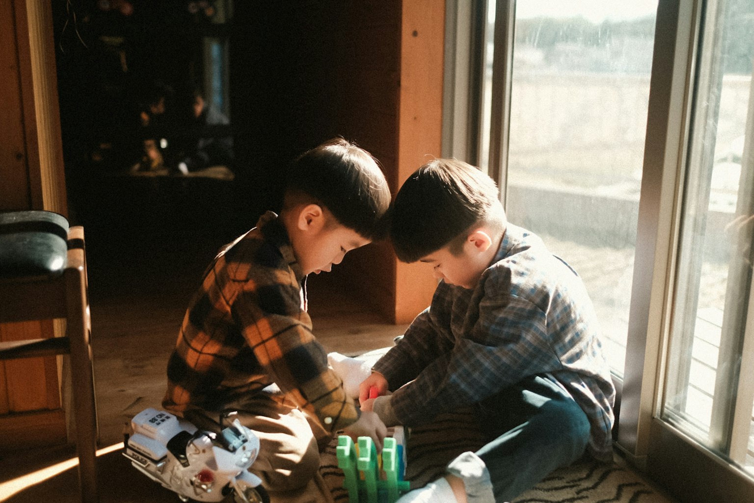 Two children playing near a window