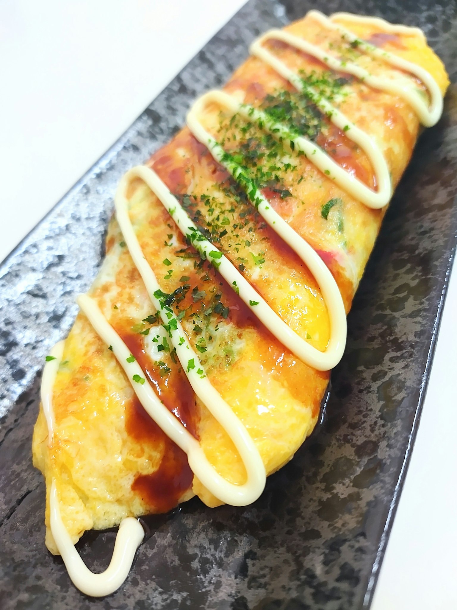 Delicioso arroz de omelette presentado en un plato negro