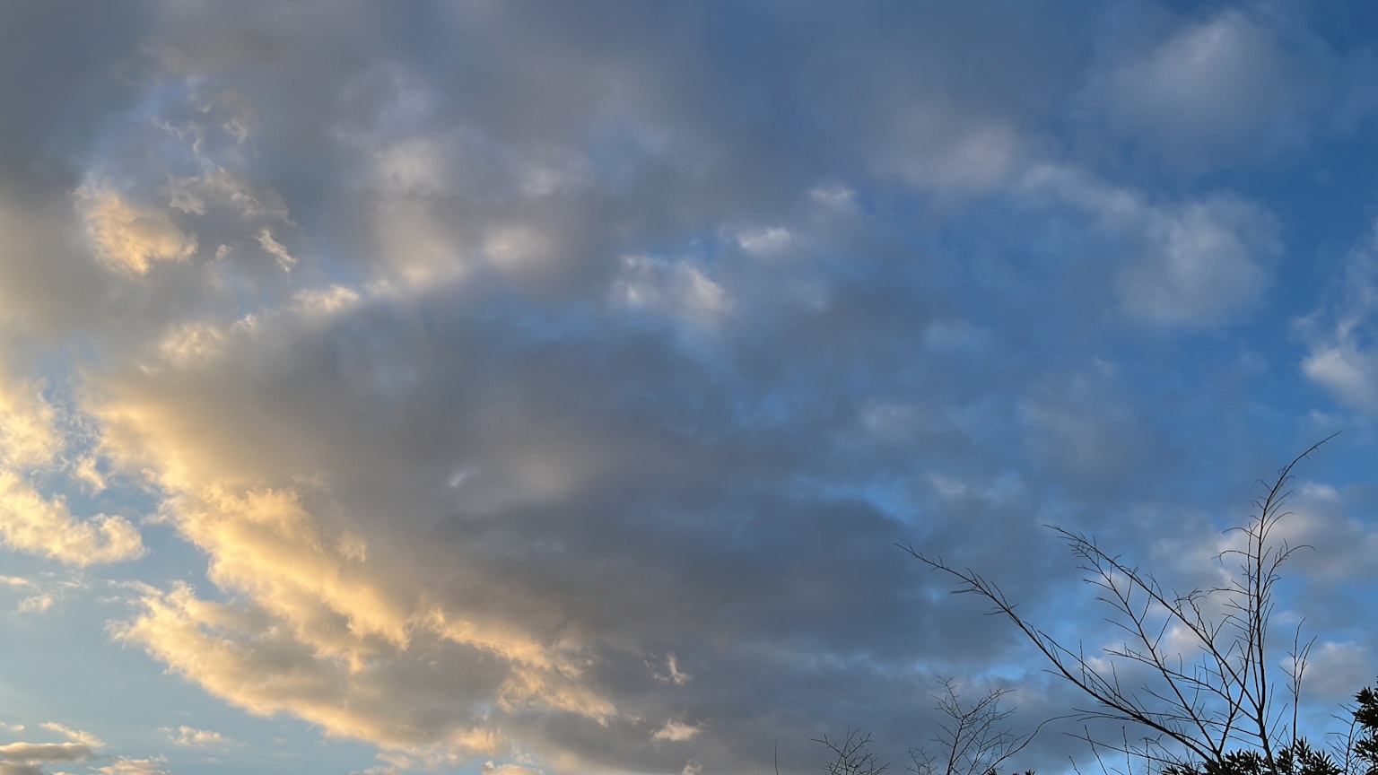 蓝天上漂浮的云朵和柔和的夕阳光
